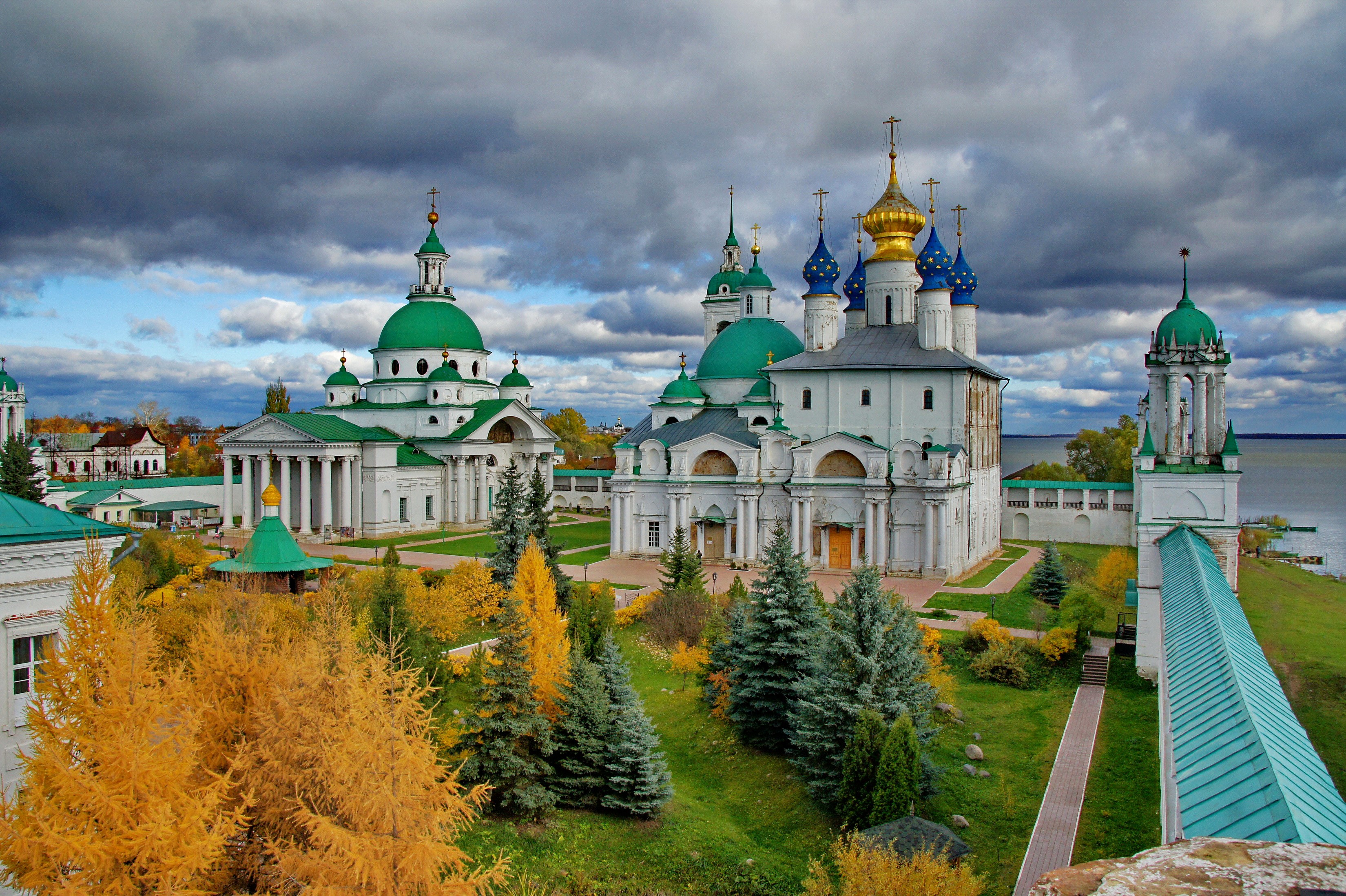 Monastery with green and golden domes under cloudy sky HD Wallpaper