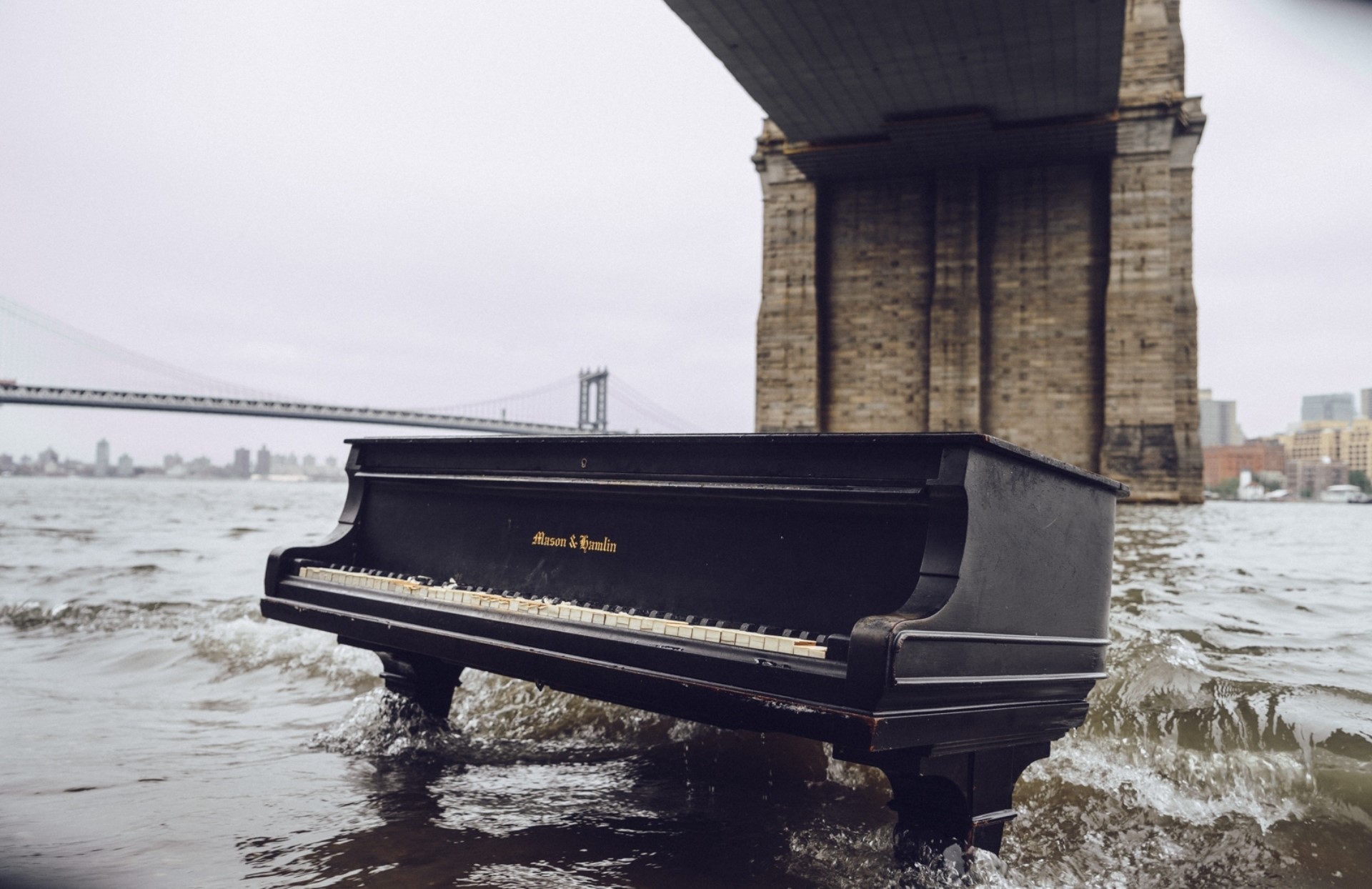 Piano submerged in water under a bridge HD Wallpaper