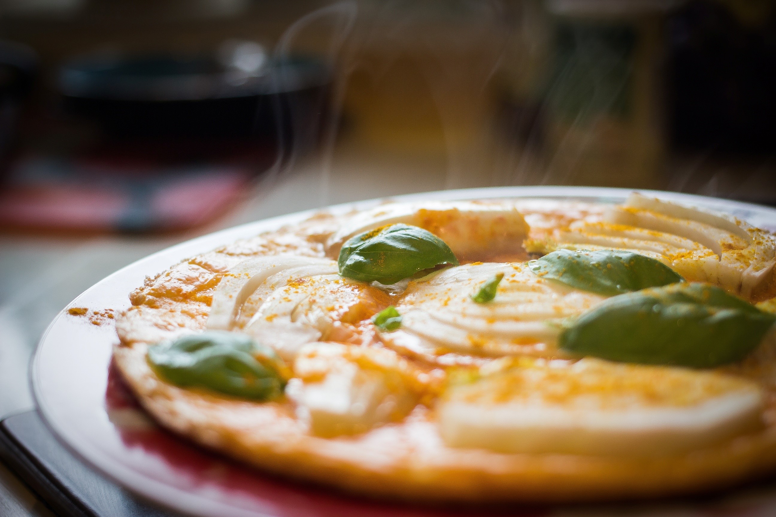 Steaming pizza with basil and onion on a plate HD Wallpaper