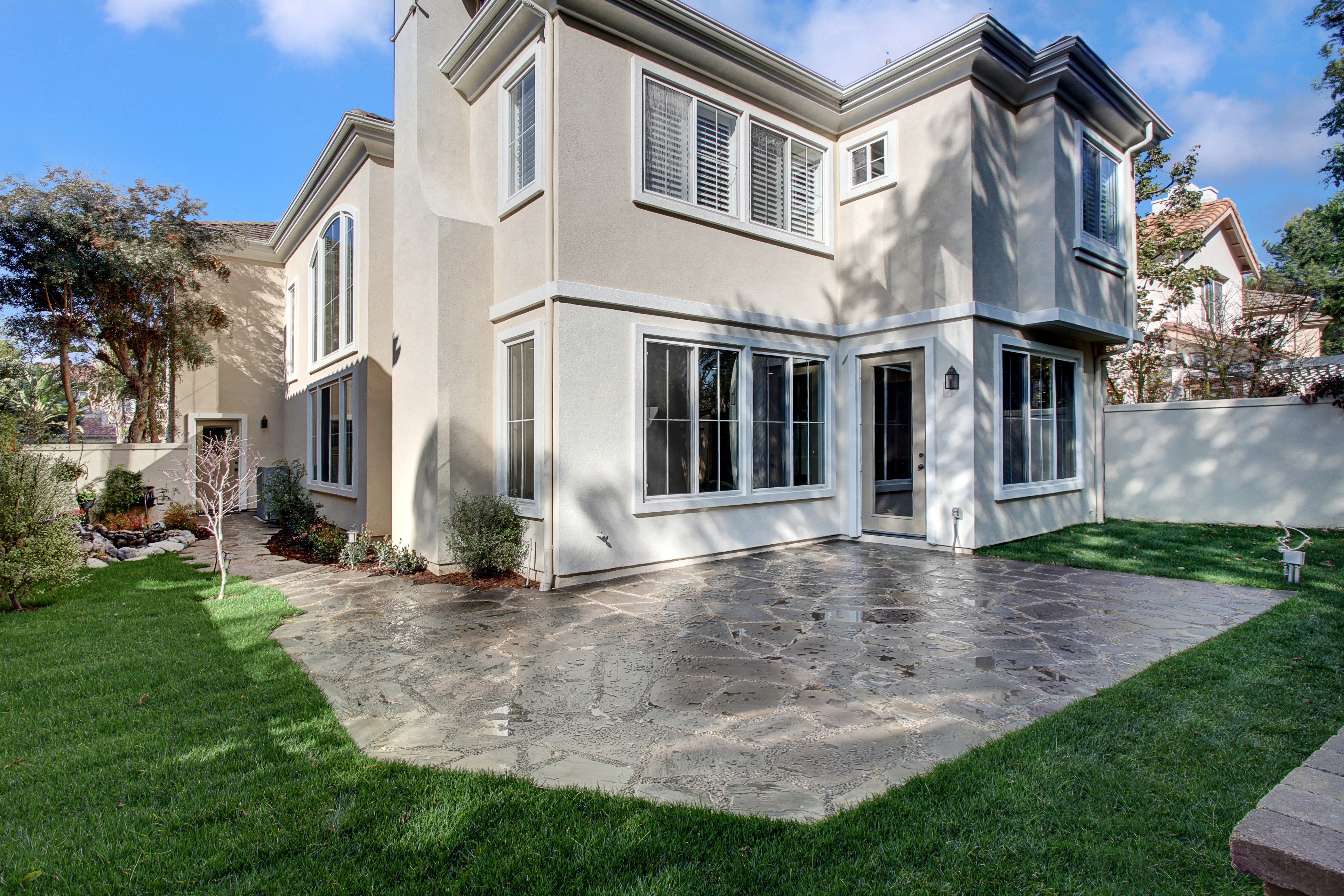 Exterior of a modern house with a patio and lawn HD Wallpaper