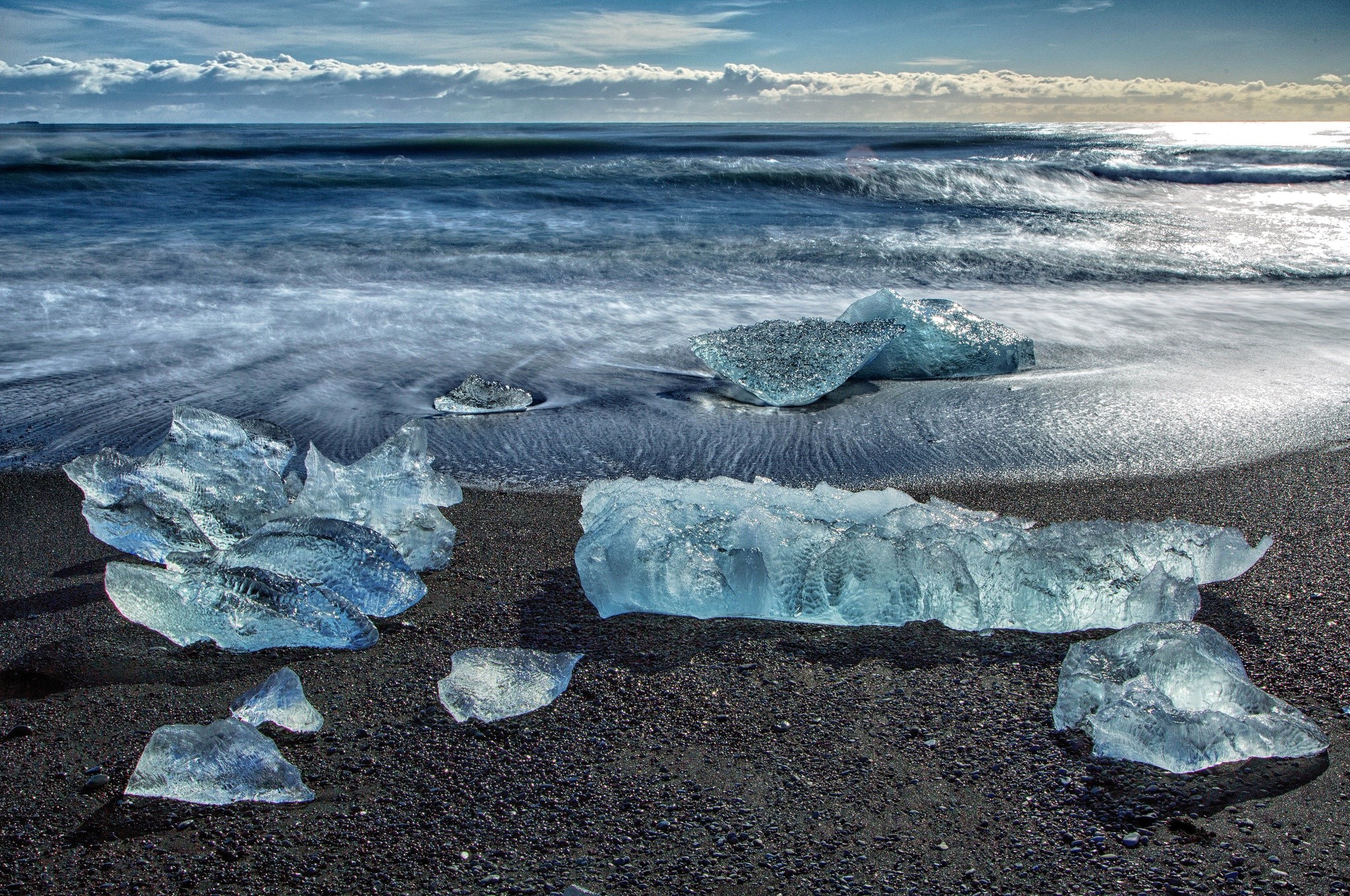 Icebergs on a black sand beach with ocean waves HD Wallpaper
