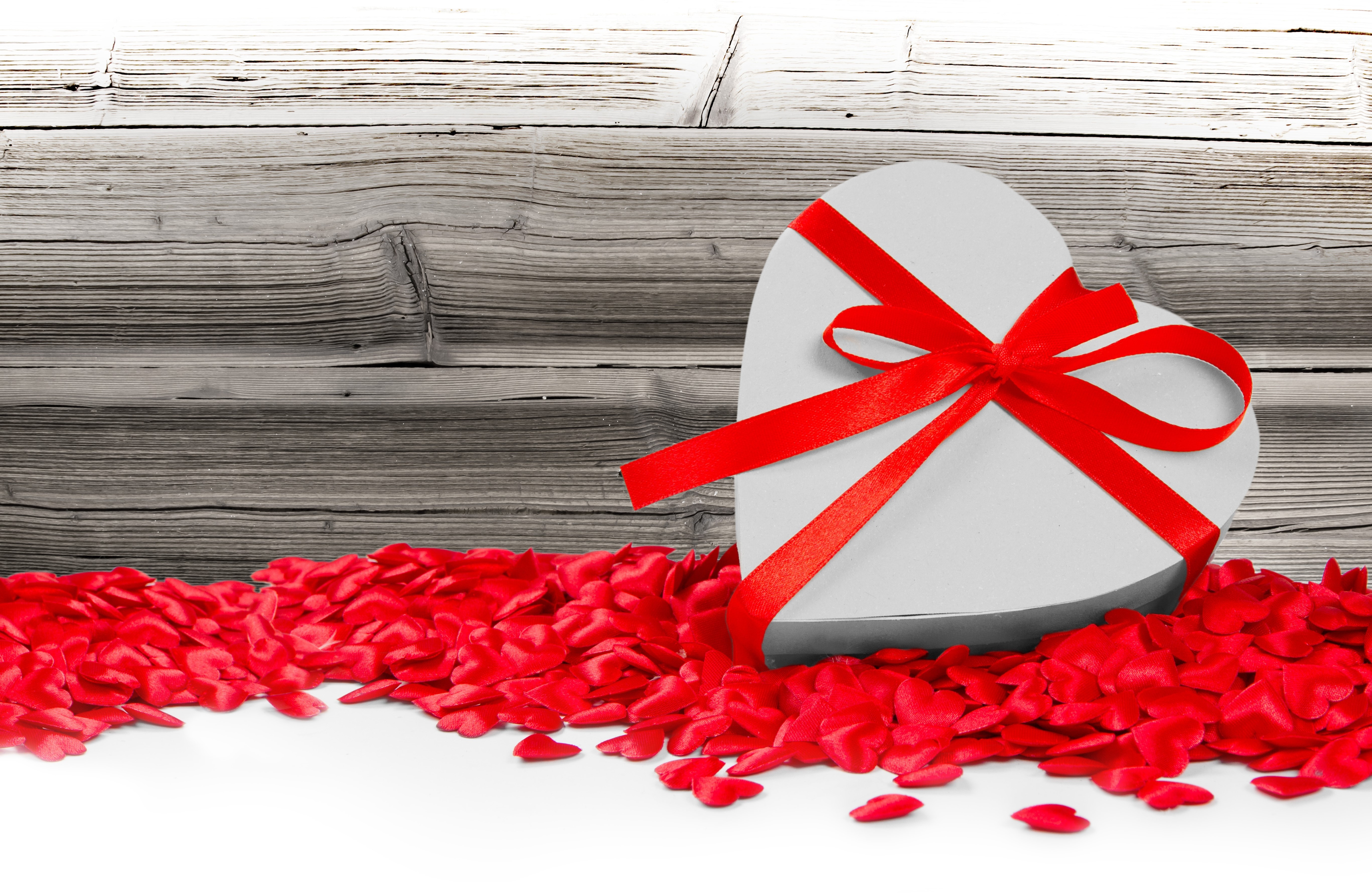 Heart-shaped gift box with red ribbon and petals HD Wallpaper