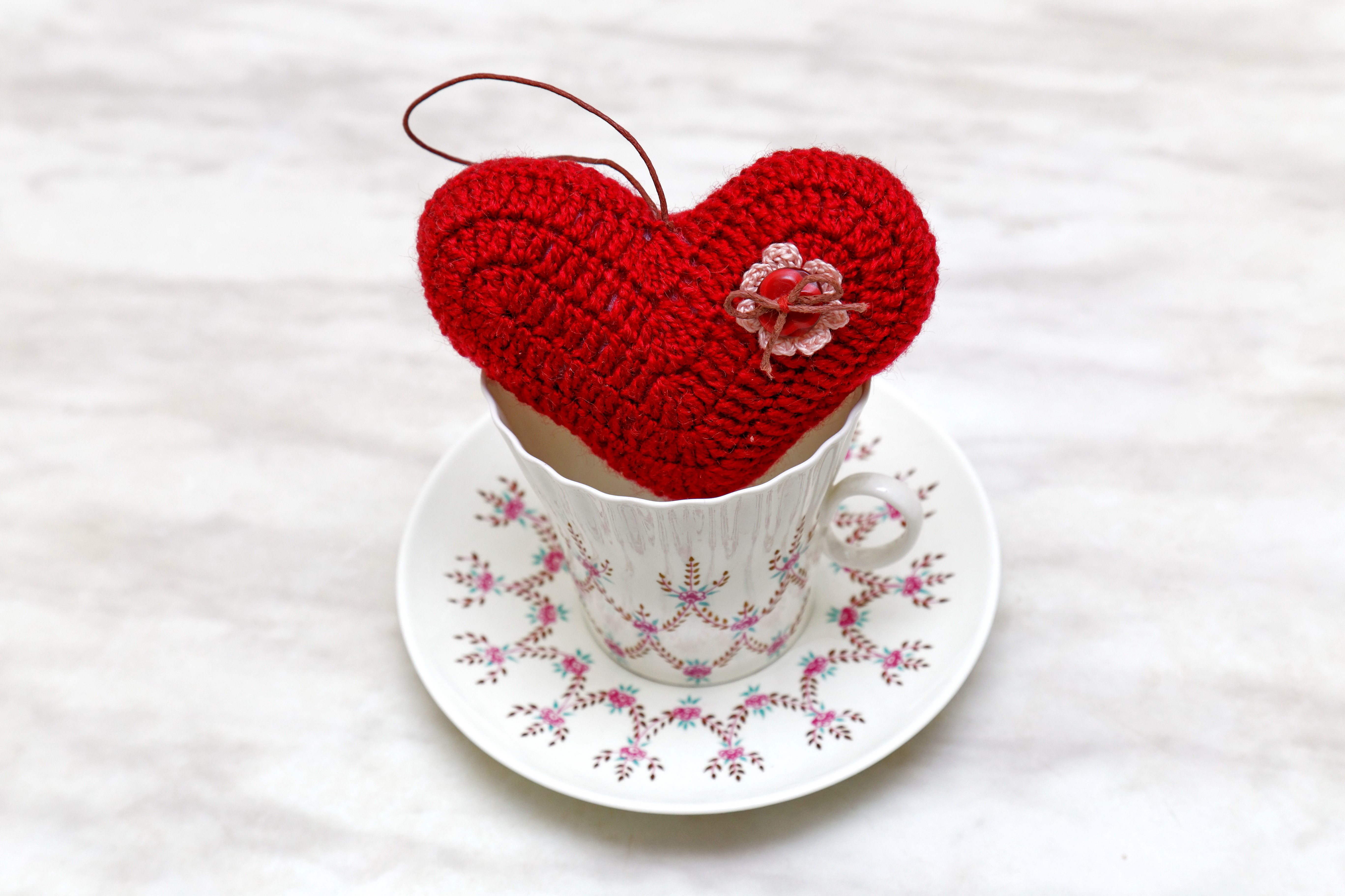 Red crocheted heart in a teacup HD Wallpaper