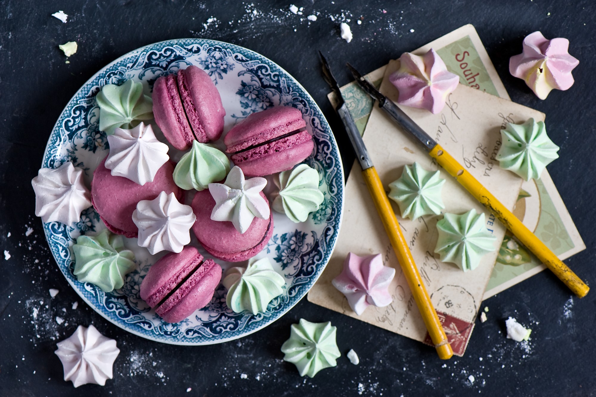 Pink macarons and meringues on a plate with vintage postcards HD Wallpaper