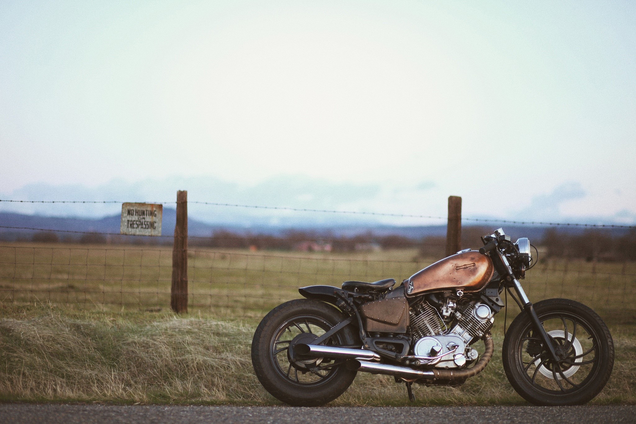 Custom Yamaha motorcycle parked by a fence HD Wallpaper