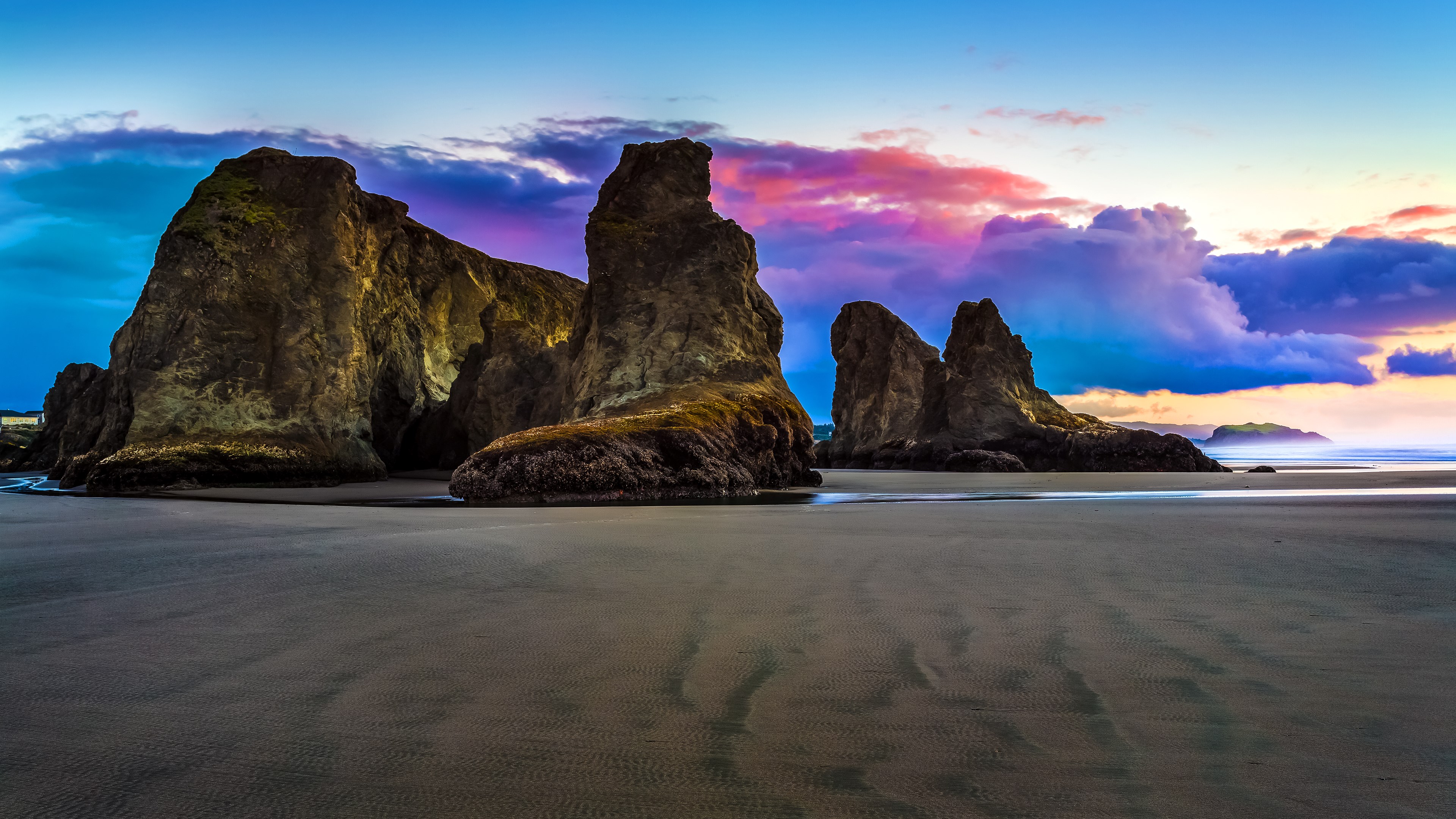 Sea stacks and colorful clouds at sunset on a beach HD Wallpaper