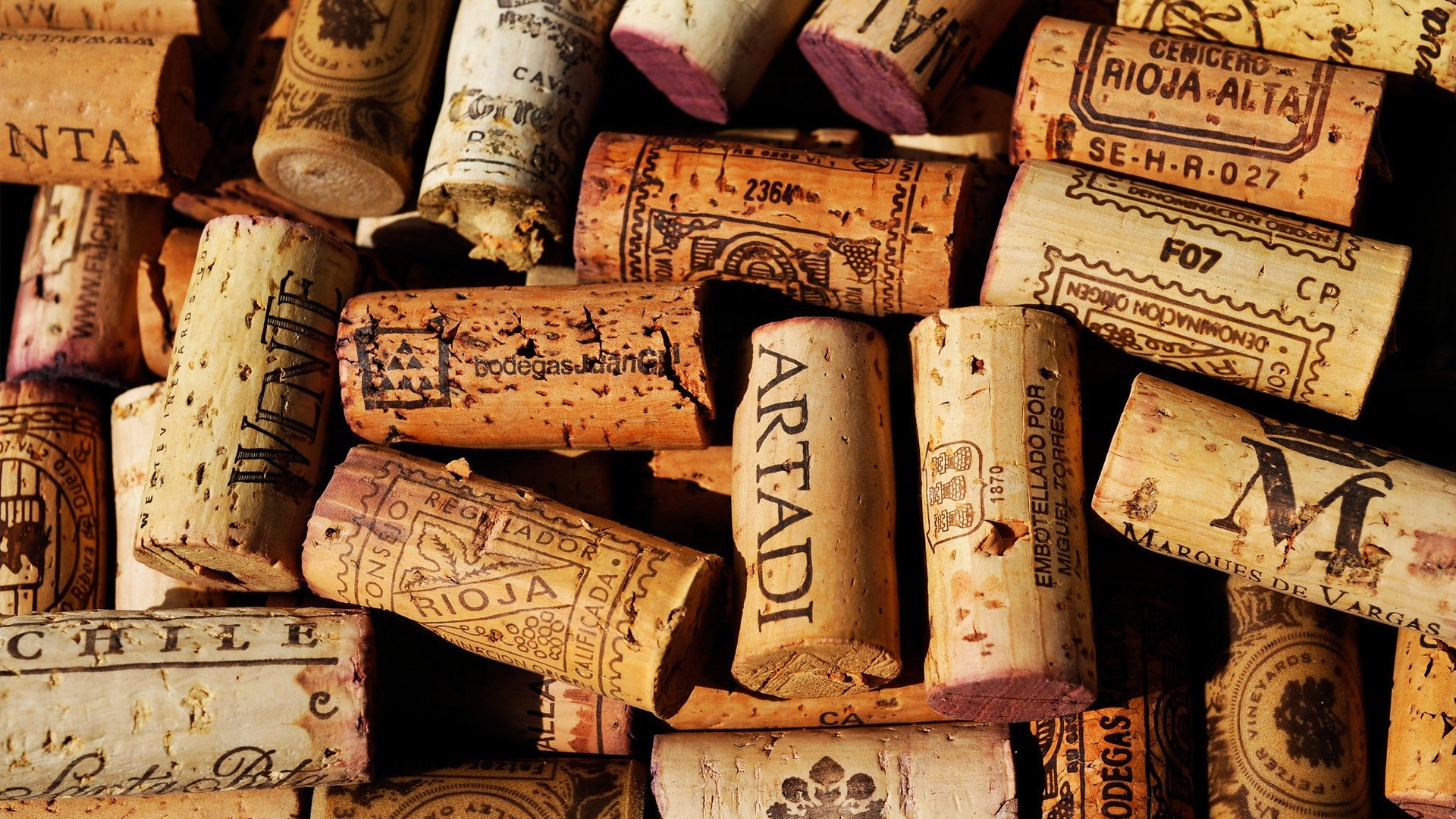 Pile of wine corks with various brandings HD Wallpaper
