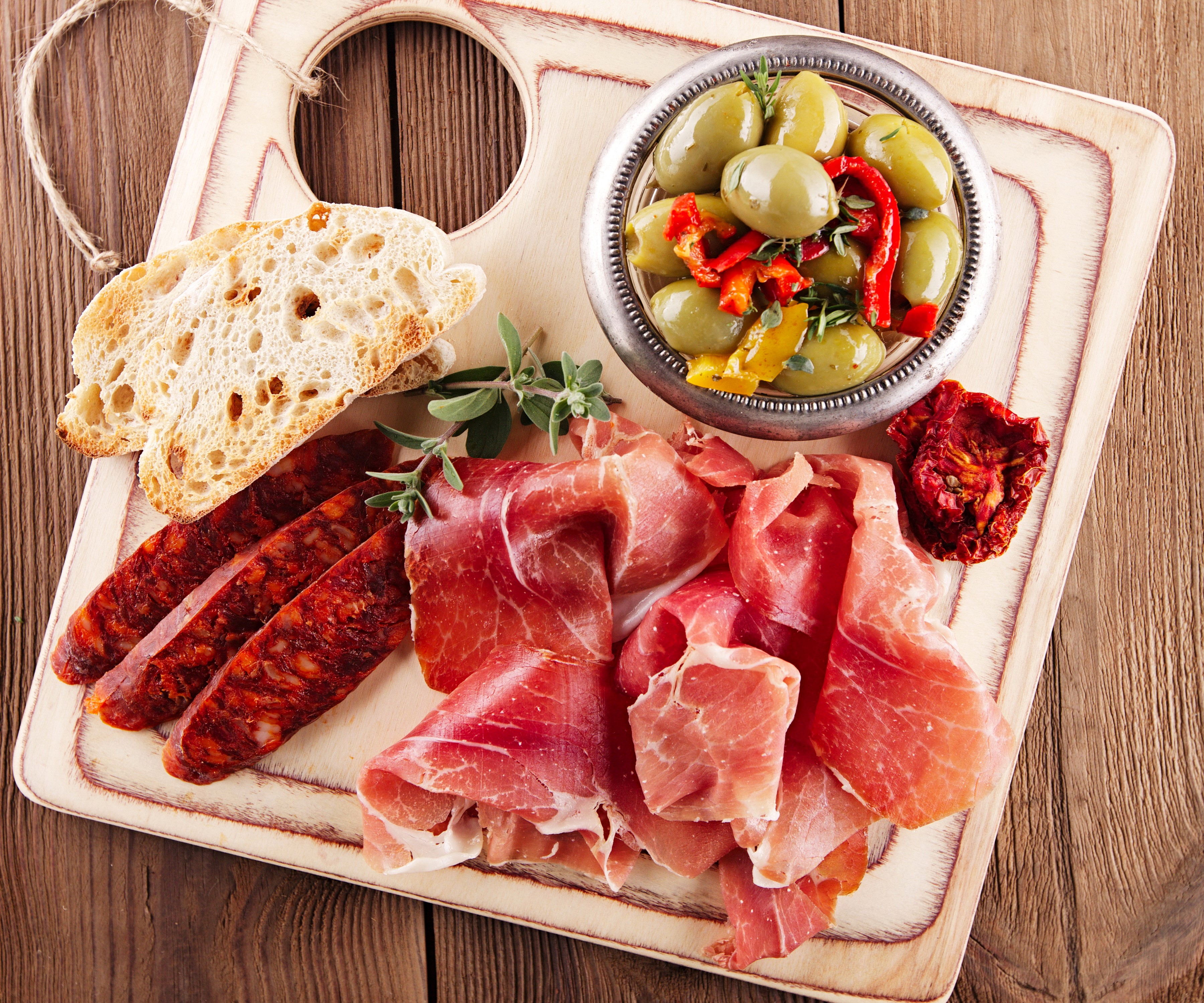 Charcuterie board with prosciutto, chorizo, bread, and olives HD Wallpaper