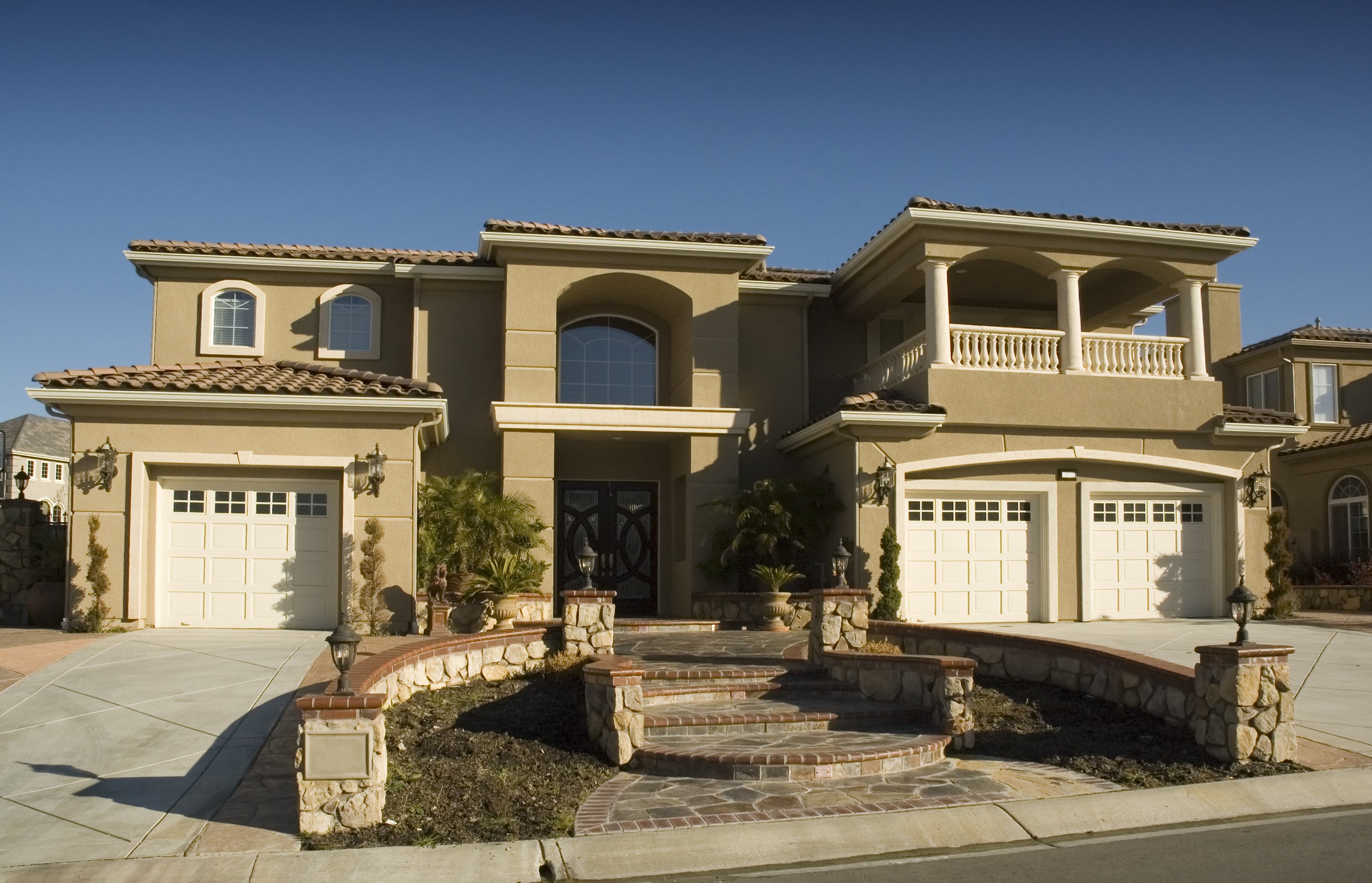 Luxury stucco house with arched windows and garages HD Wallpaper