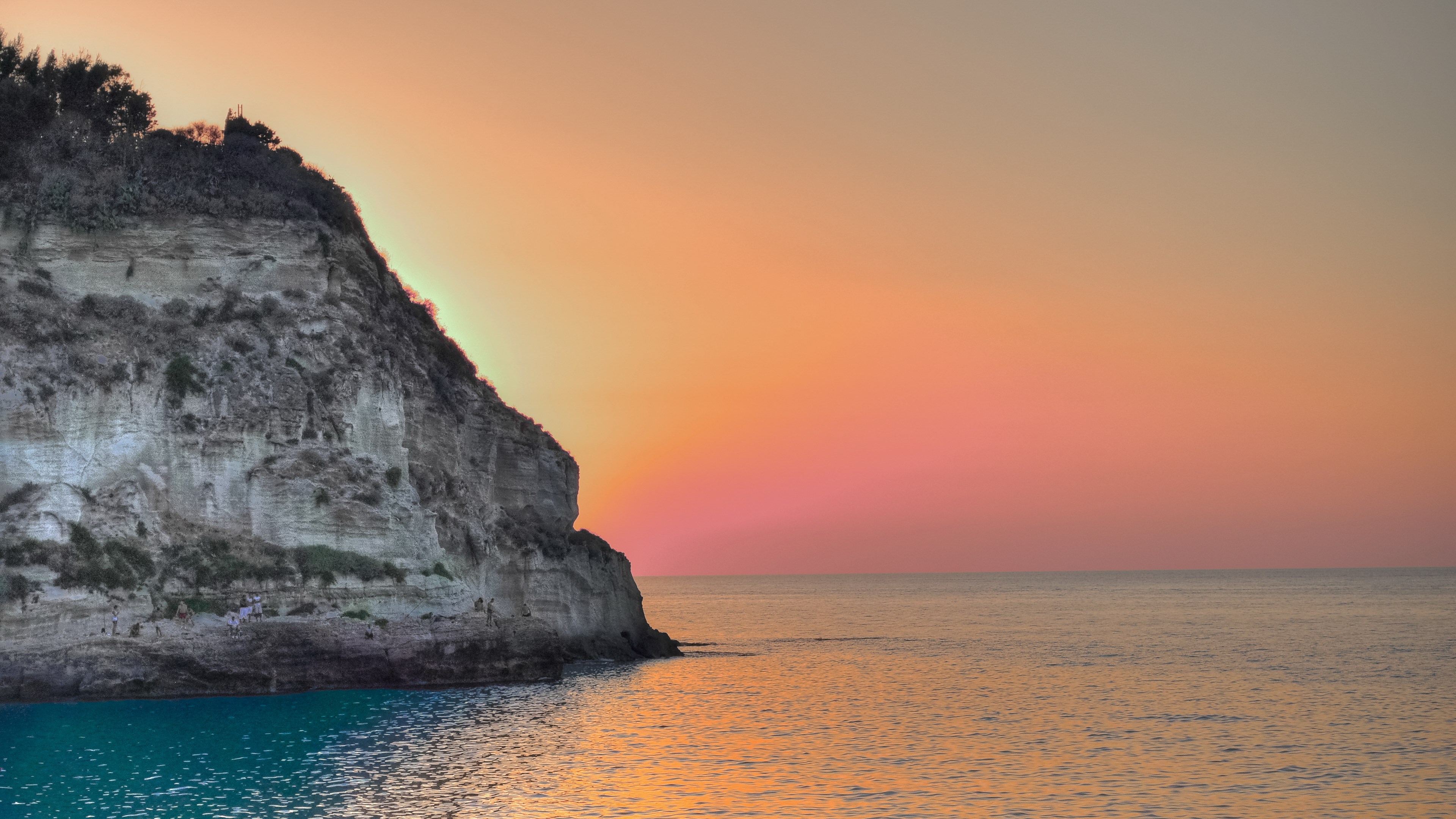 Cliff overlooking the ocean at sunset HD Wallpaper
