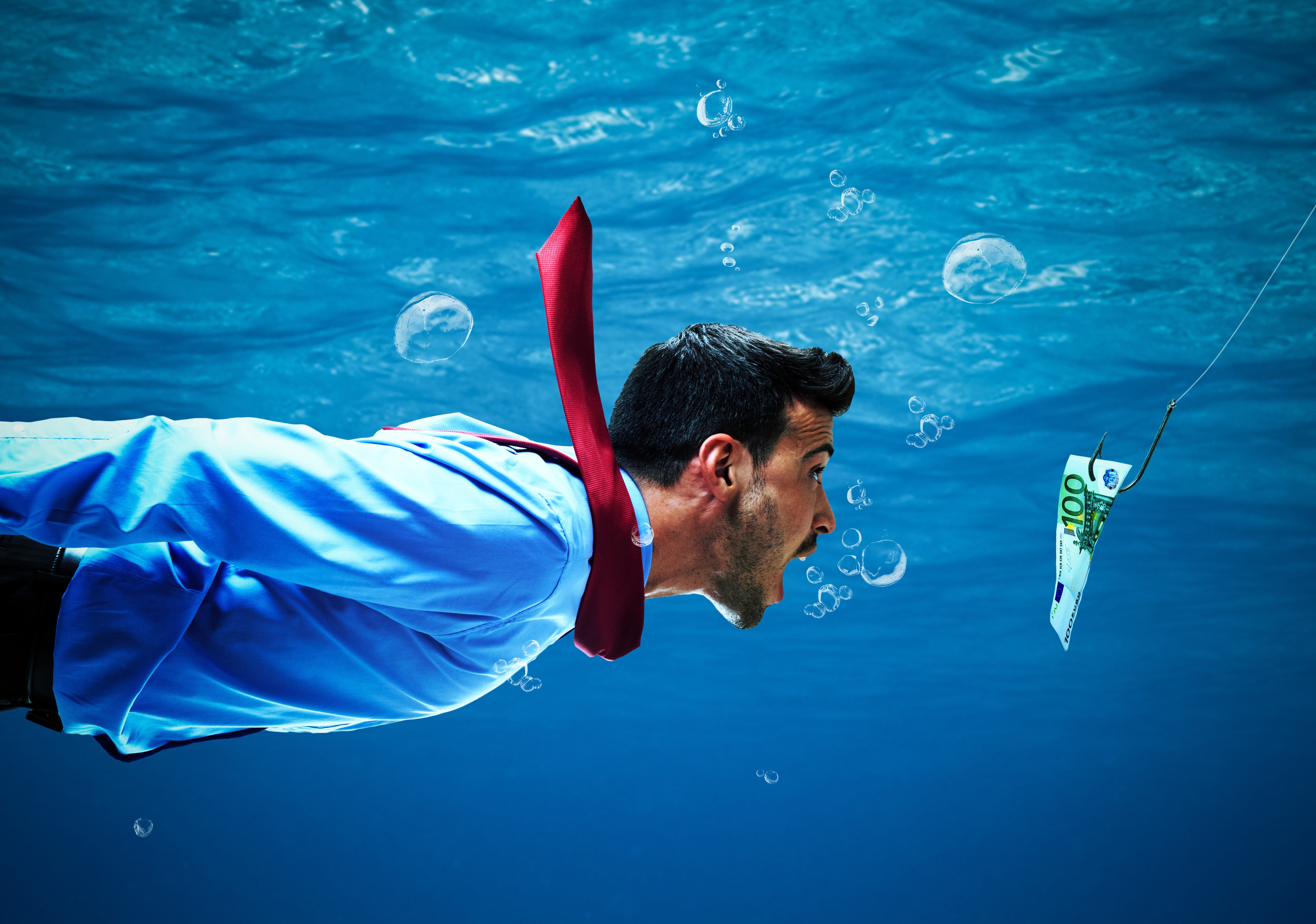 Man in suit underwater chasing money on a hook HD Wallpaper