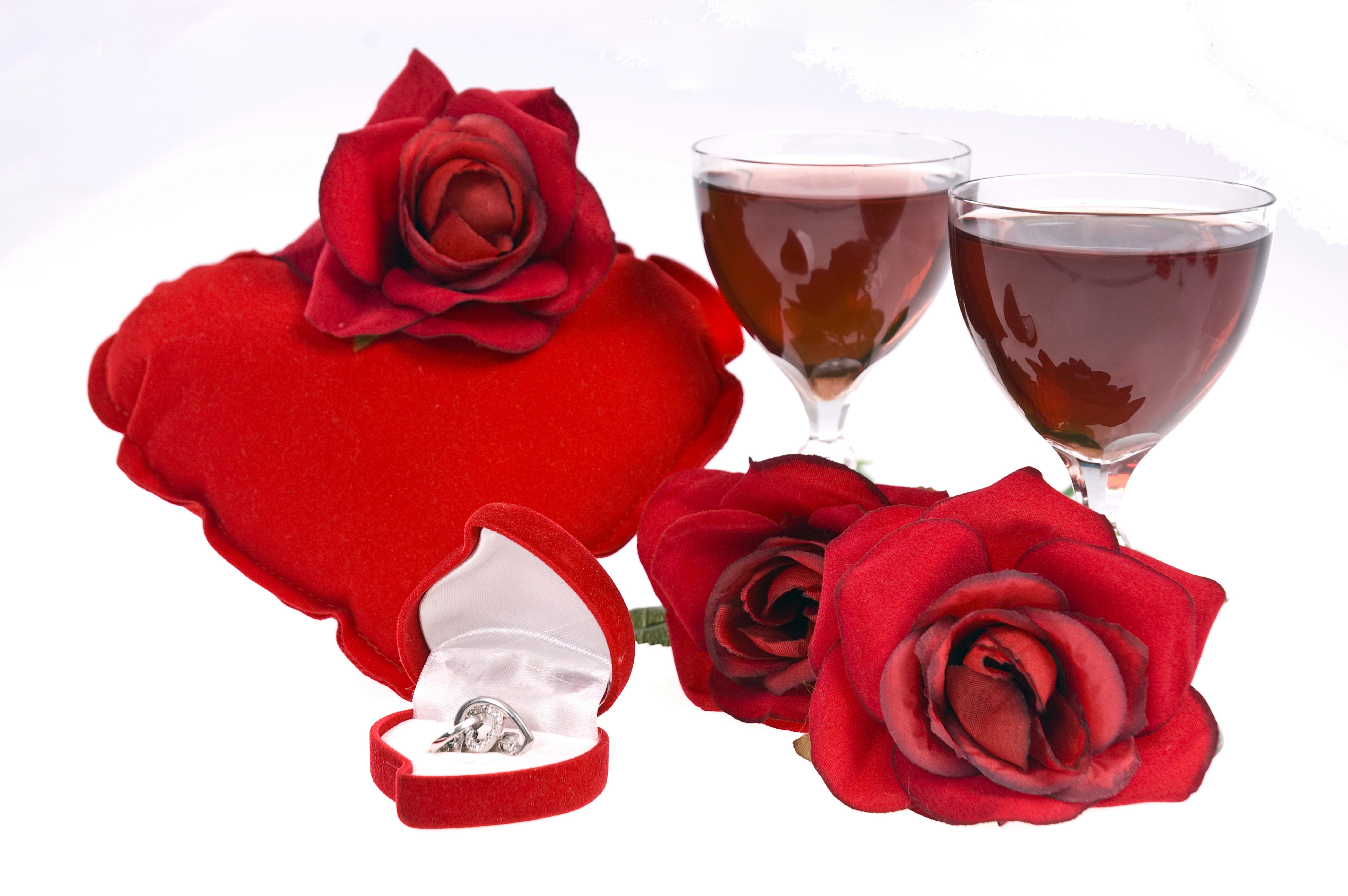 Red roses, wine glasses, and engagement ring on a heart pillow HD Wallpaper