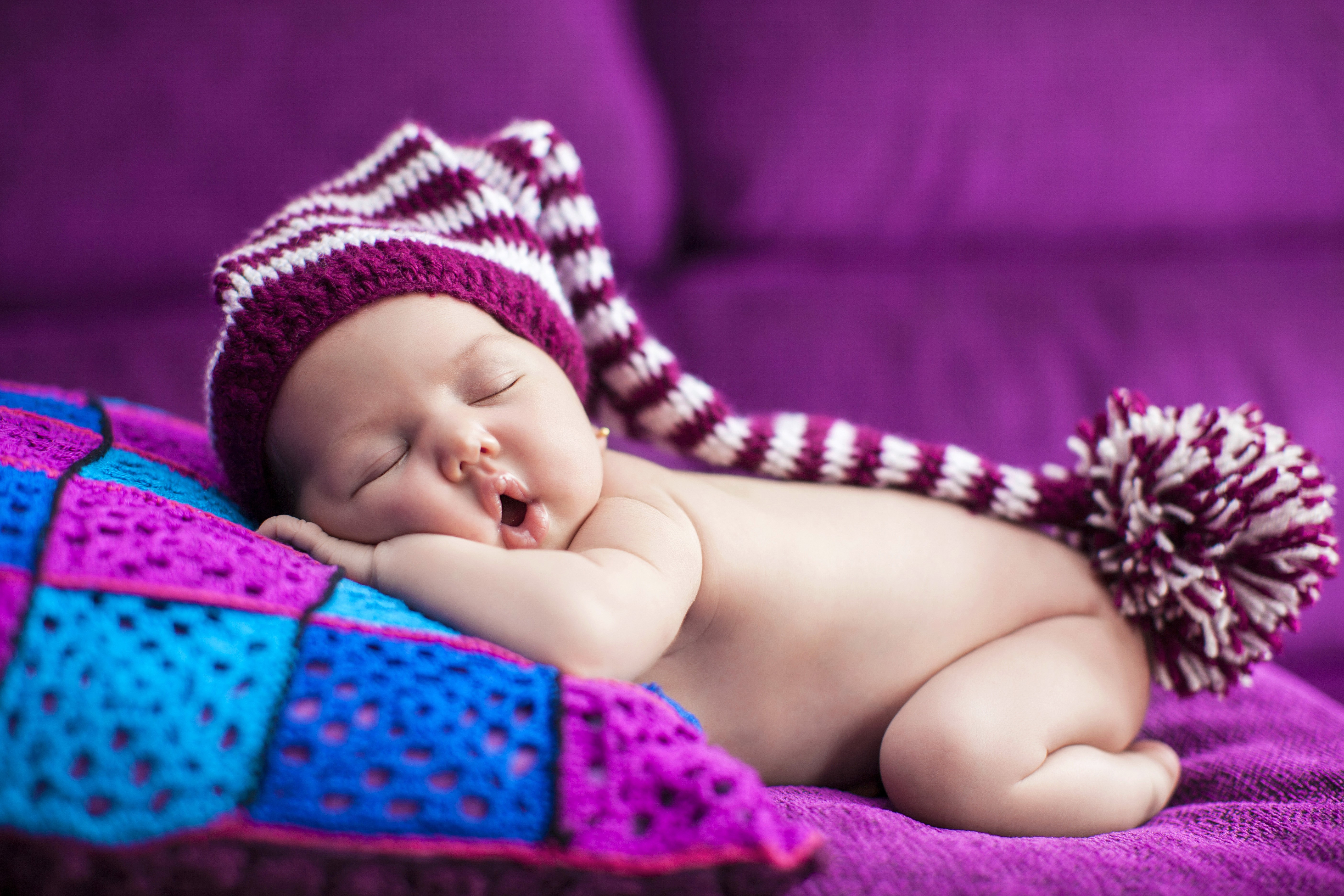 Baby sleeping in a striped winter hat HD Wallpaper