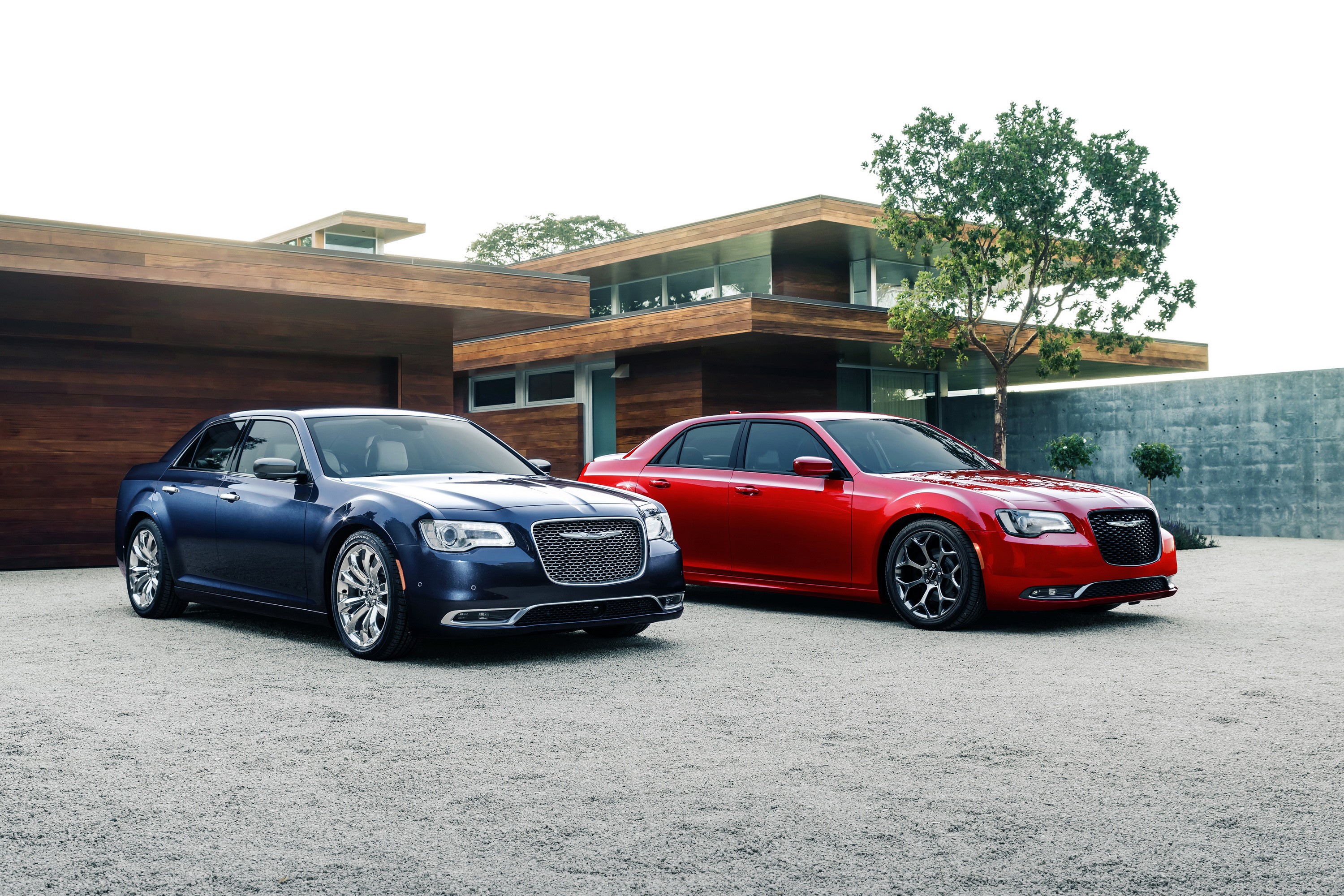 Two Chrysler 300 C sedans parked in front of a modern house HD Wallpaper