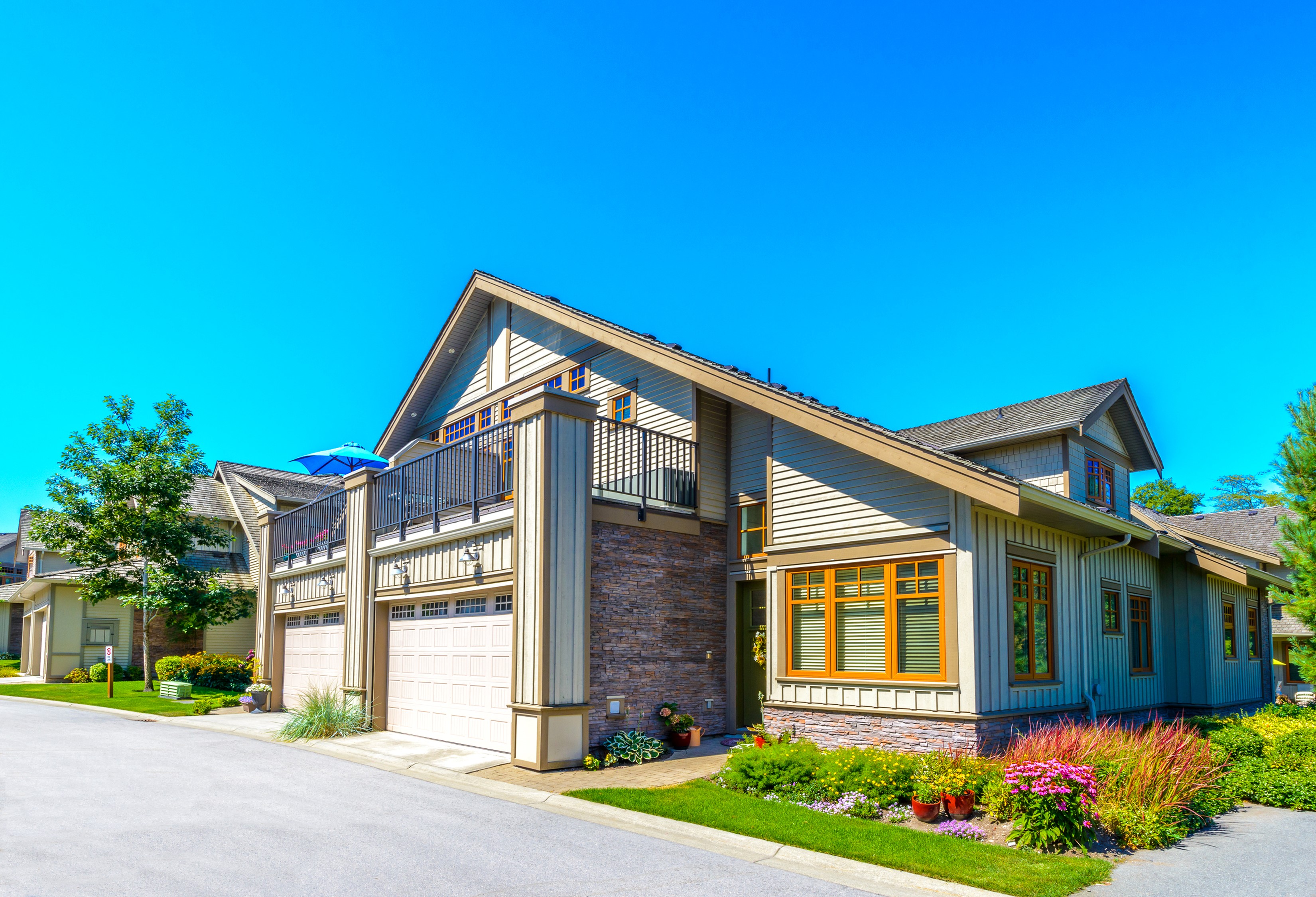 Townhouses with garages and balconies on a sunny day HD Wallpaper