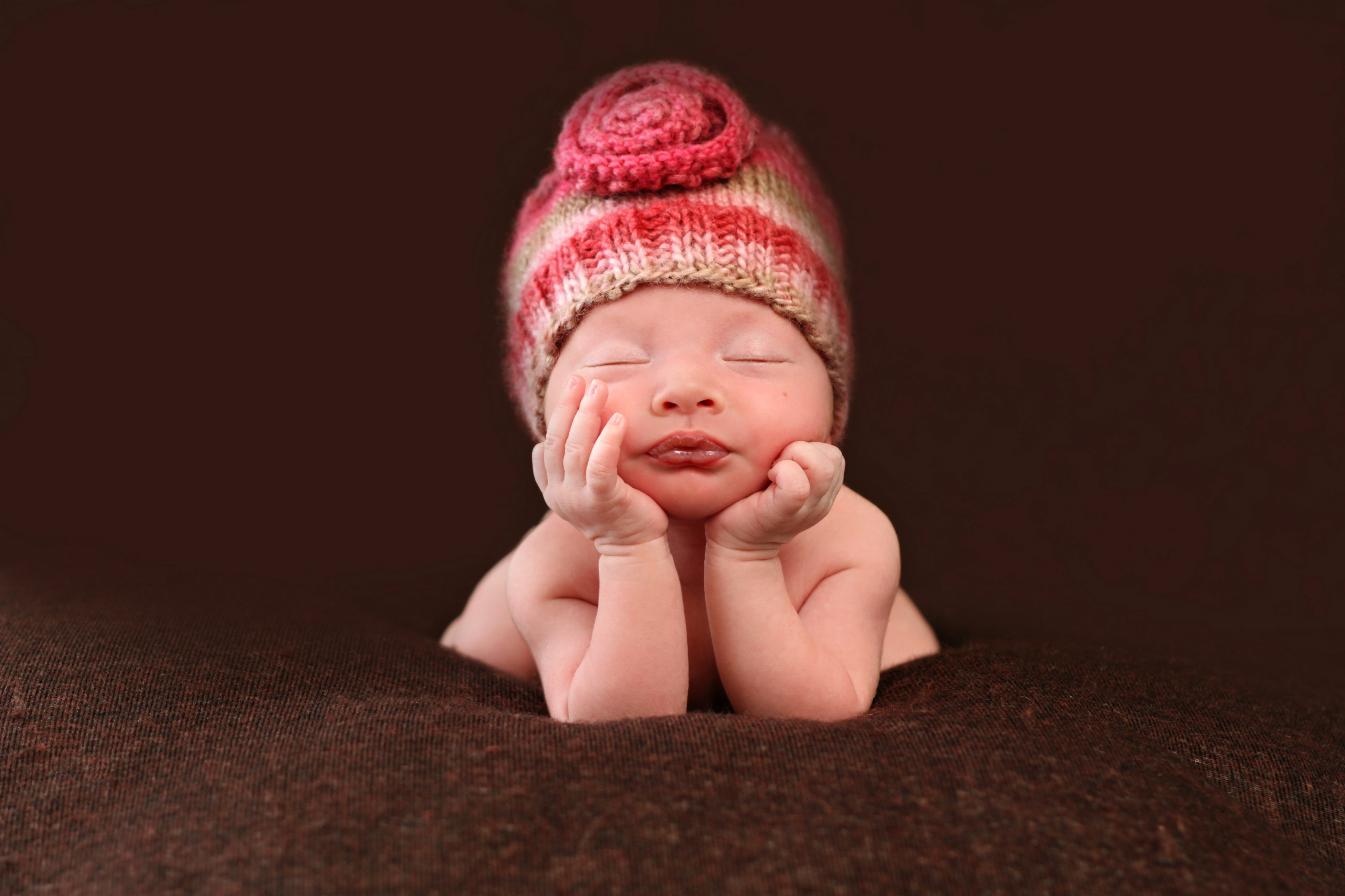 Baby wearing a striped winter hat sleeping HD Wallpaper