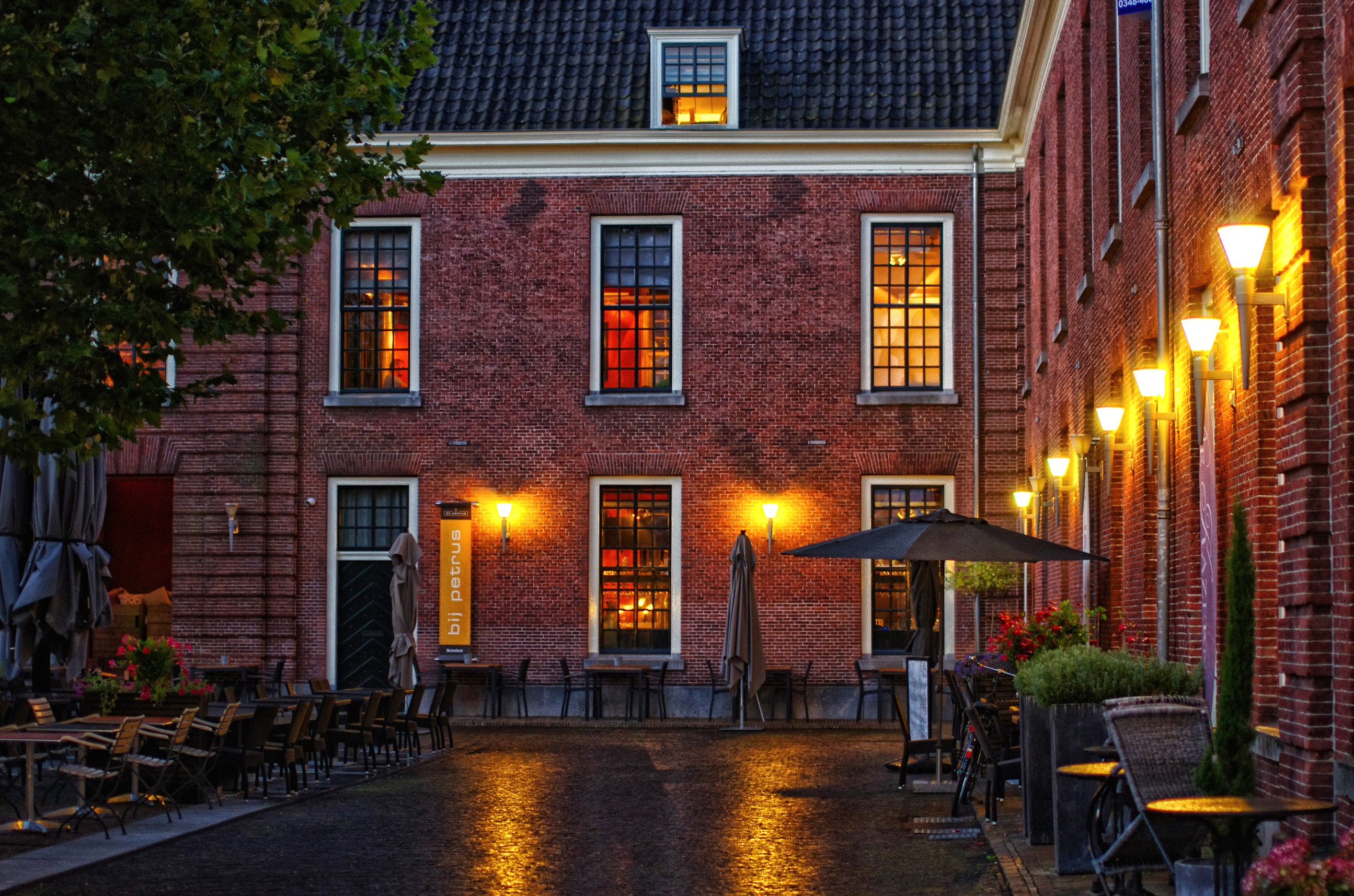 Street lights illuminate a brick building at night in Woerden, Netherlands HD Wallpaper