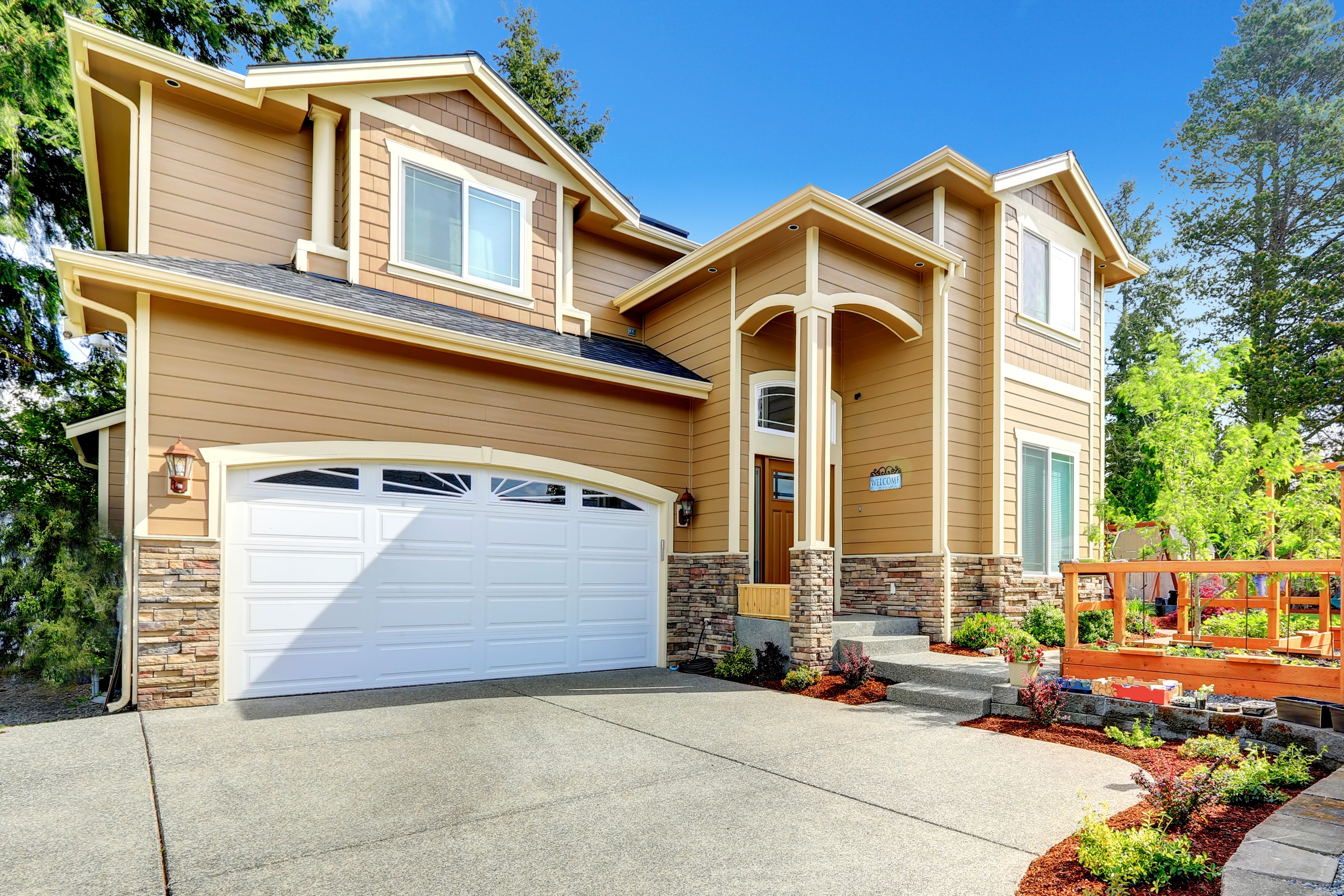 Two-story tan house with garage and landscaping HD Wallpaper
