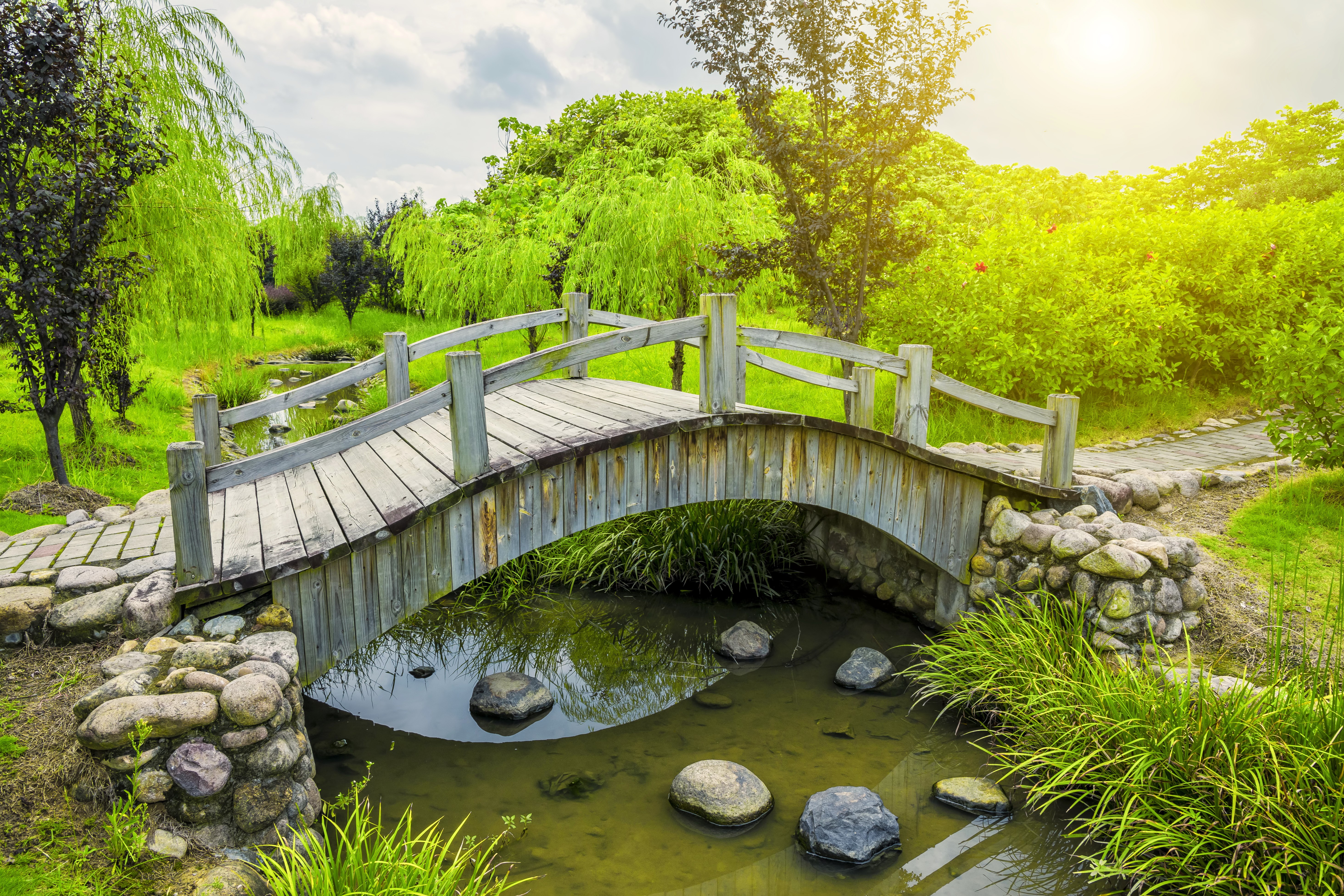 Wooden bridge over a stream in a park HD Wallpaper