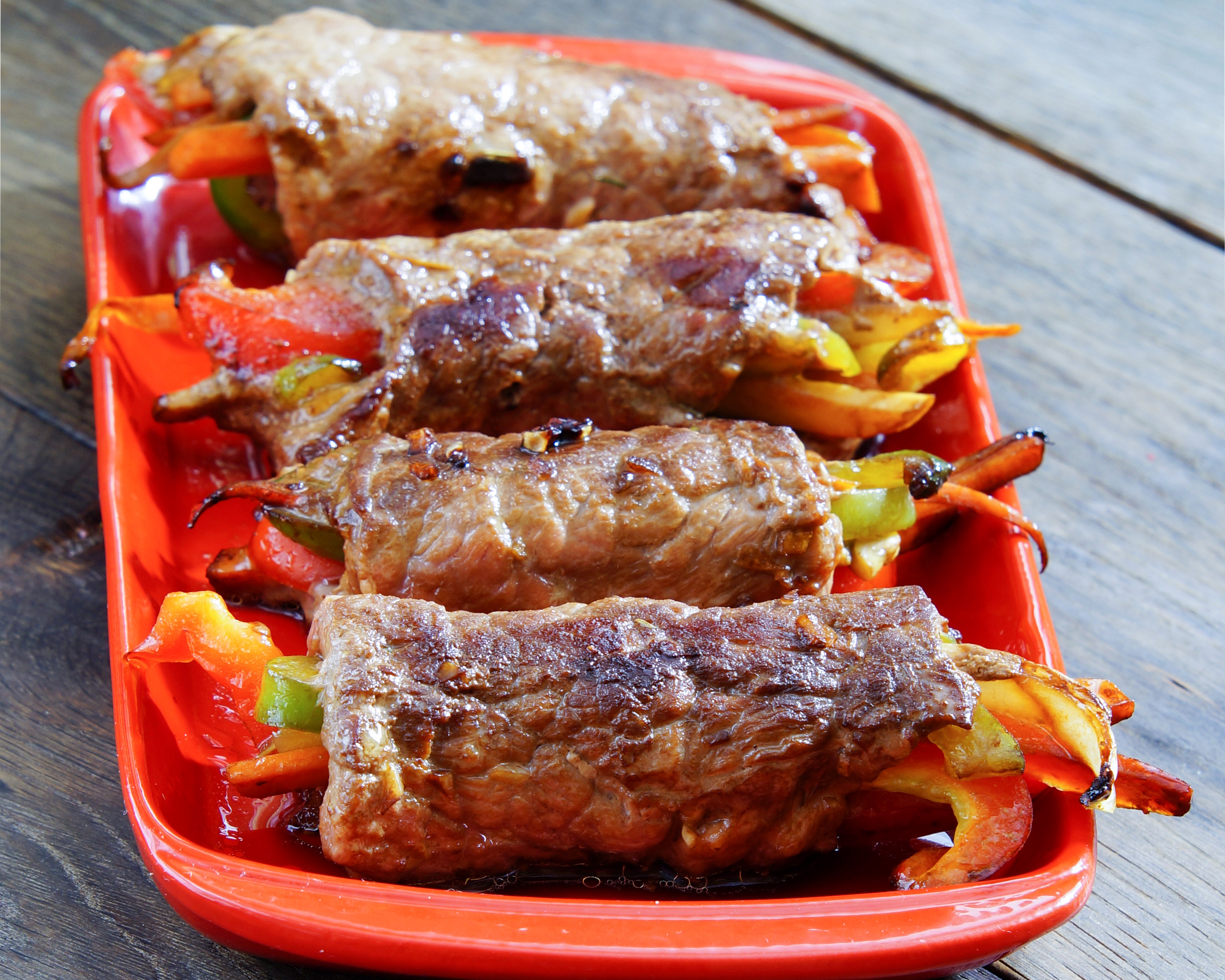 Meat rolls with bell peppers on a red plate HD Wallpaper