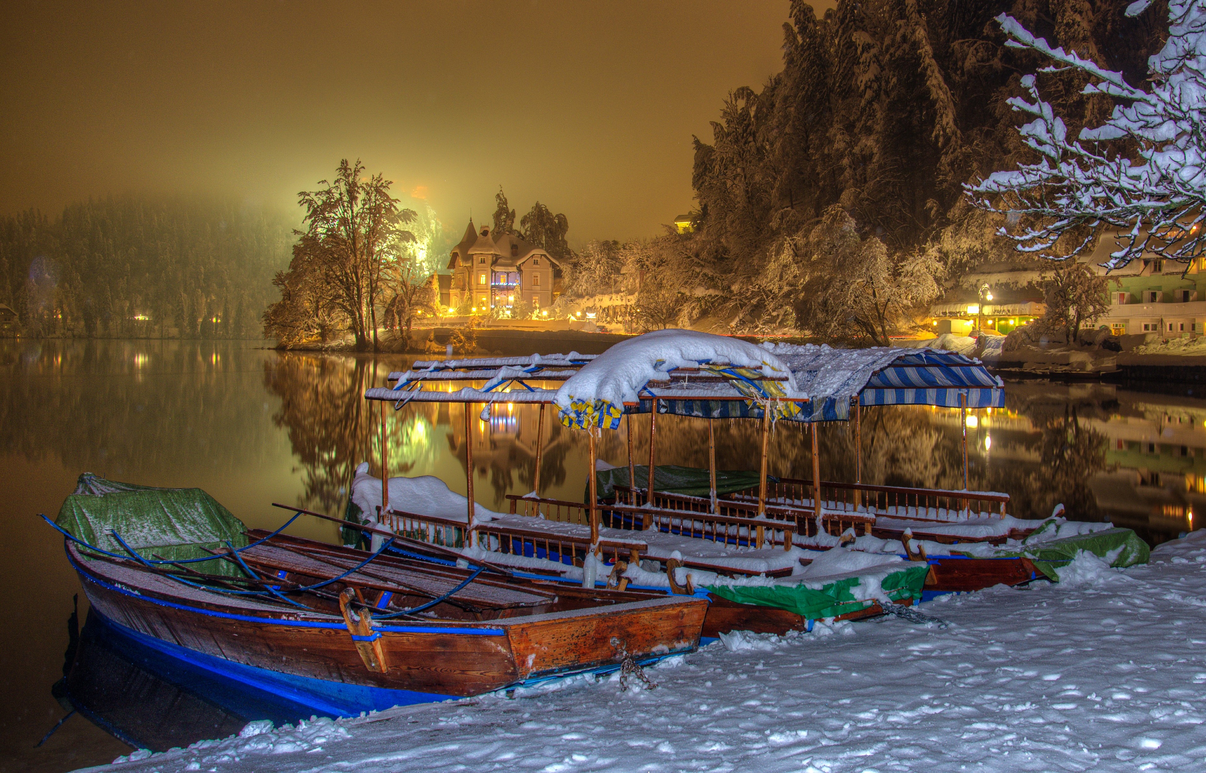 Boats on a snowy lake at night in Bled, Slovenia HD Wallpaper