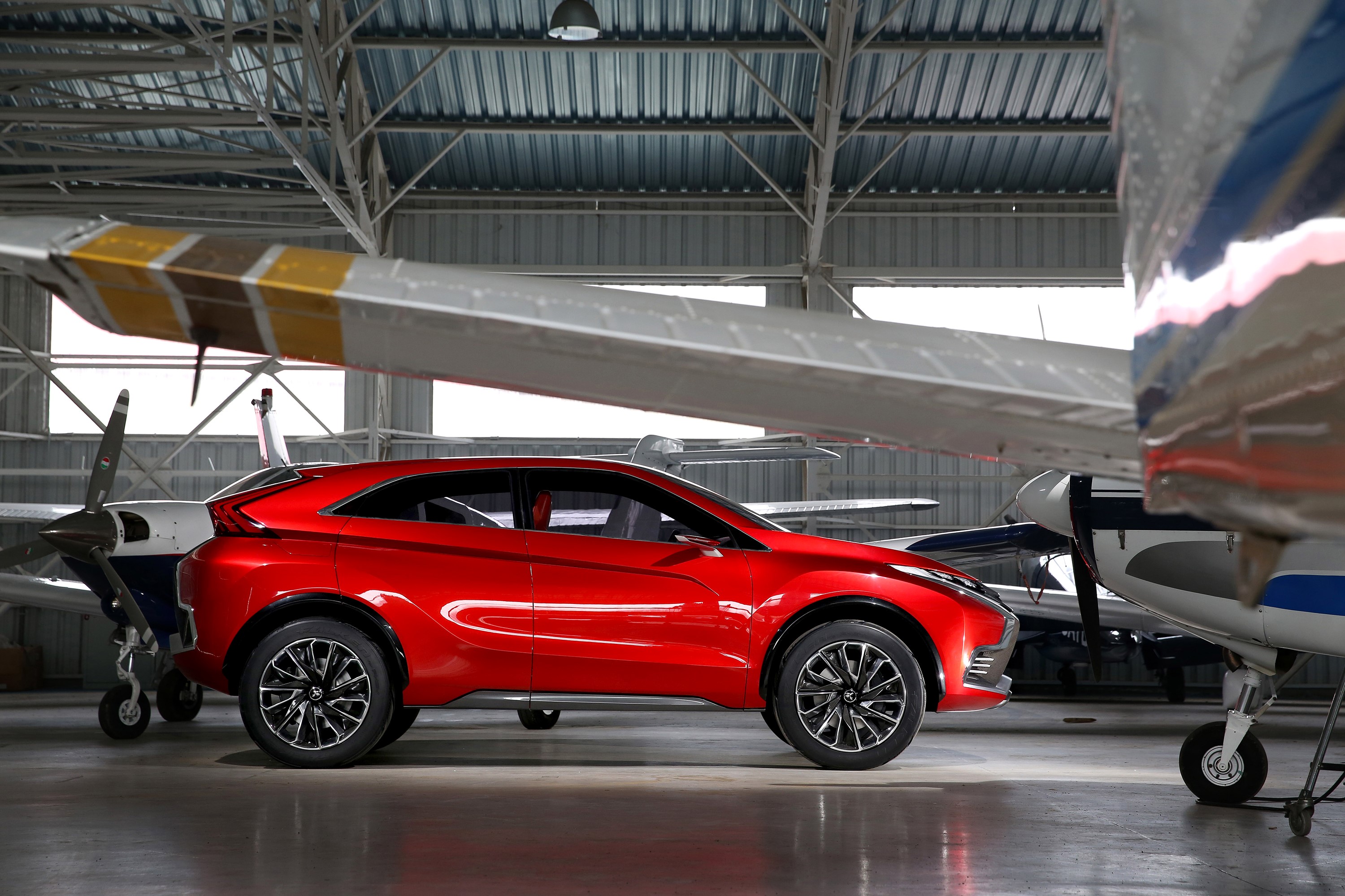 Red Mitsubishi XR-PHEV II concept car in hangar HD Wallpaper