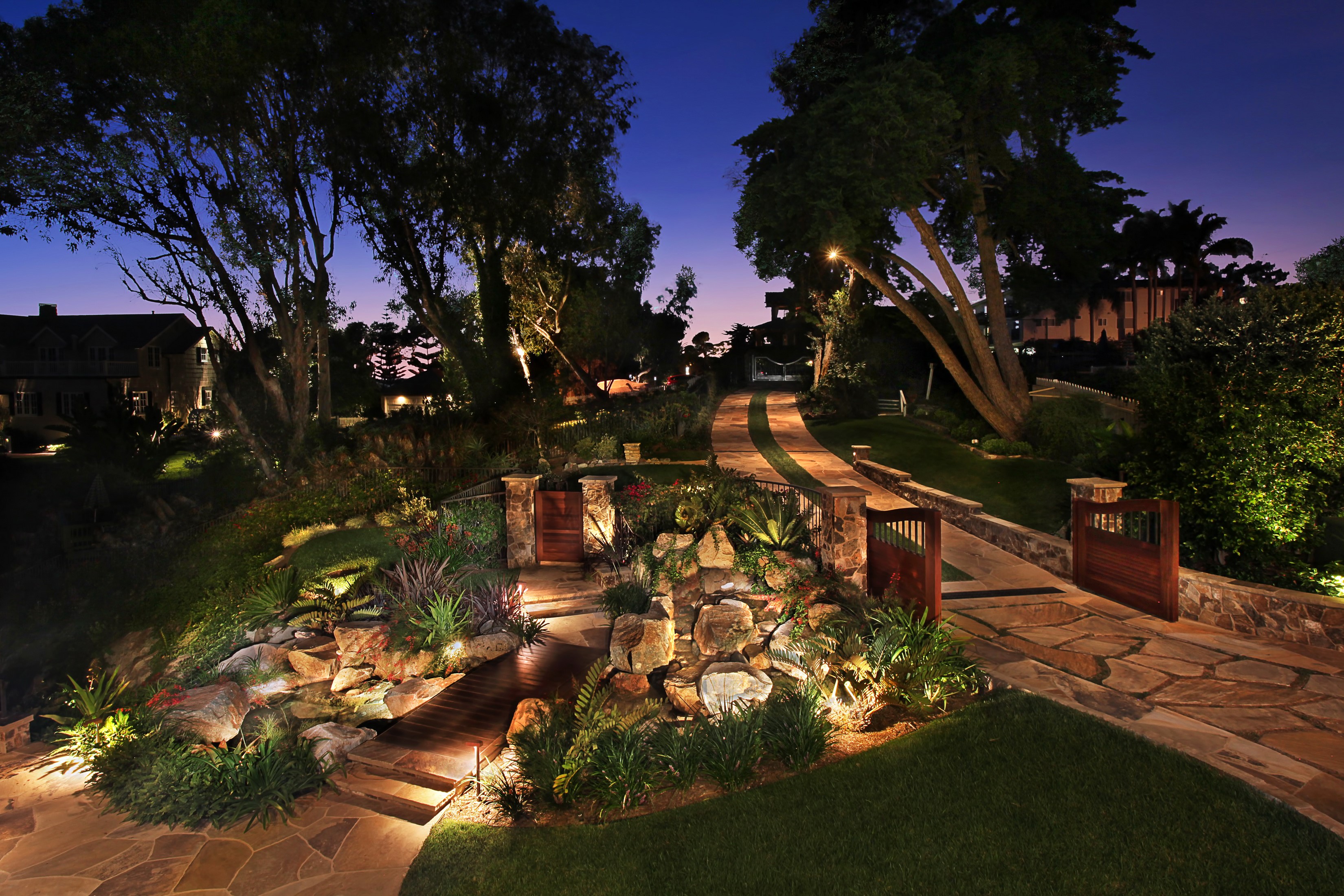 Illuminated garden path and waterfall at dusk HD Wallpaper