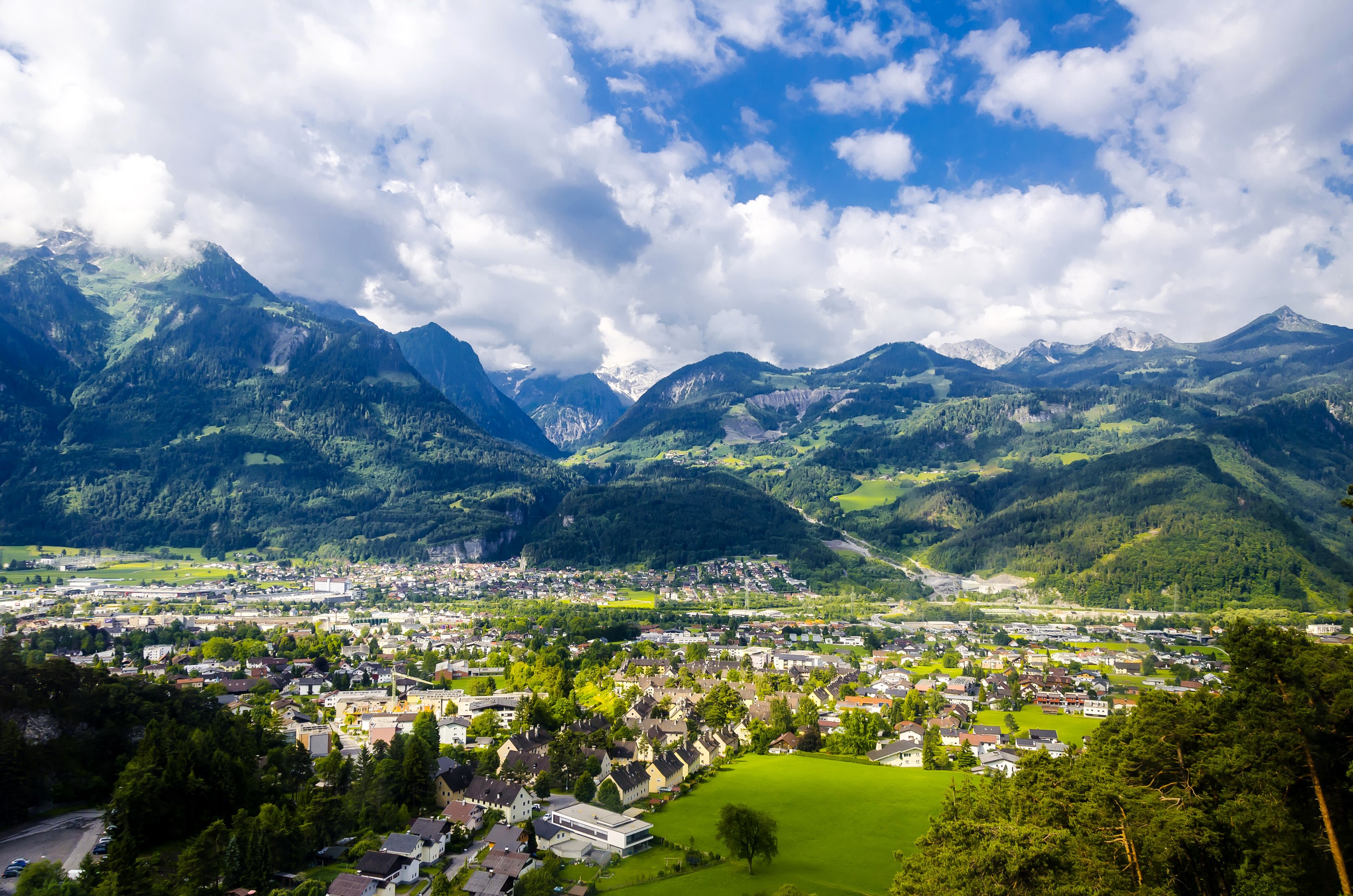 Town nestled in a valley with mountains in Austria HD Wallpaper