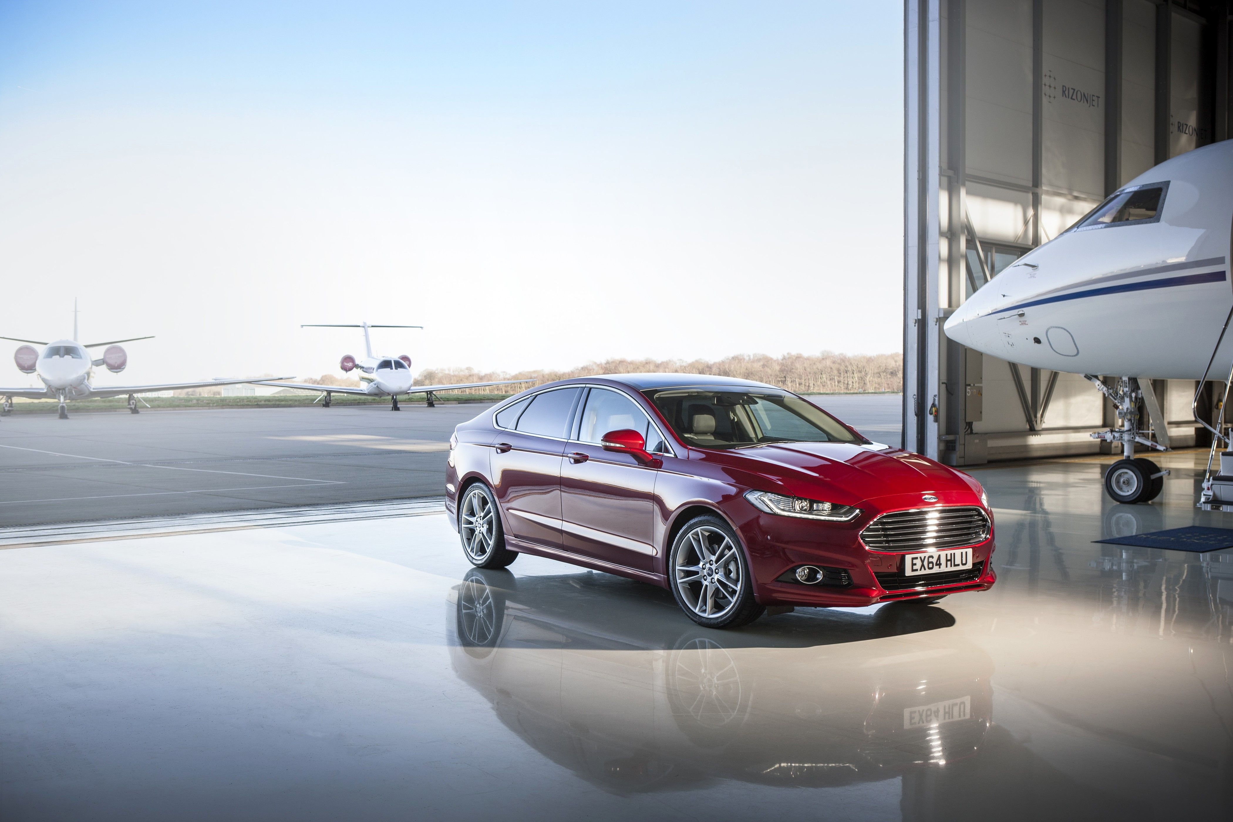 4K Ford Mondeo parked at an airport hangar with private jets HD Wallpaper