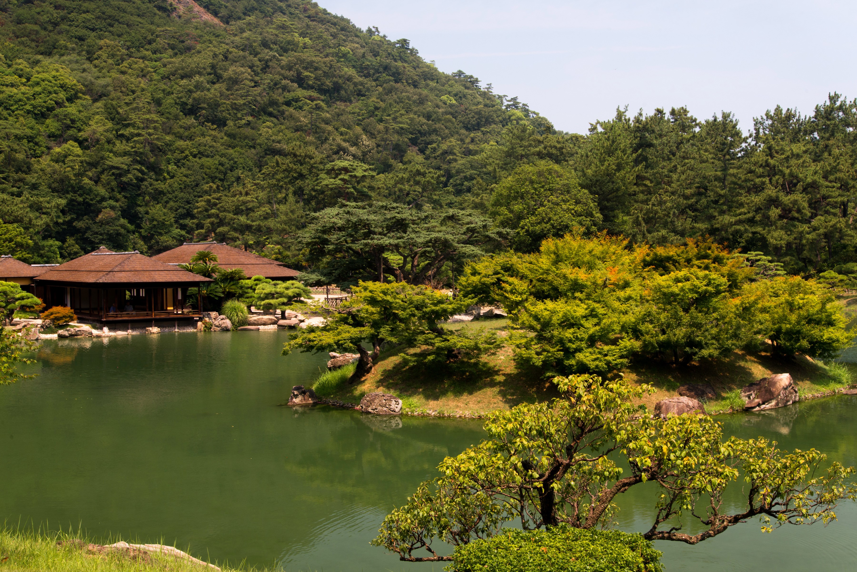 Ritsurin Garden with pond and traditional Japanese buildings HD Wallpaper