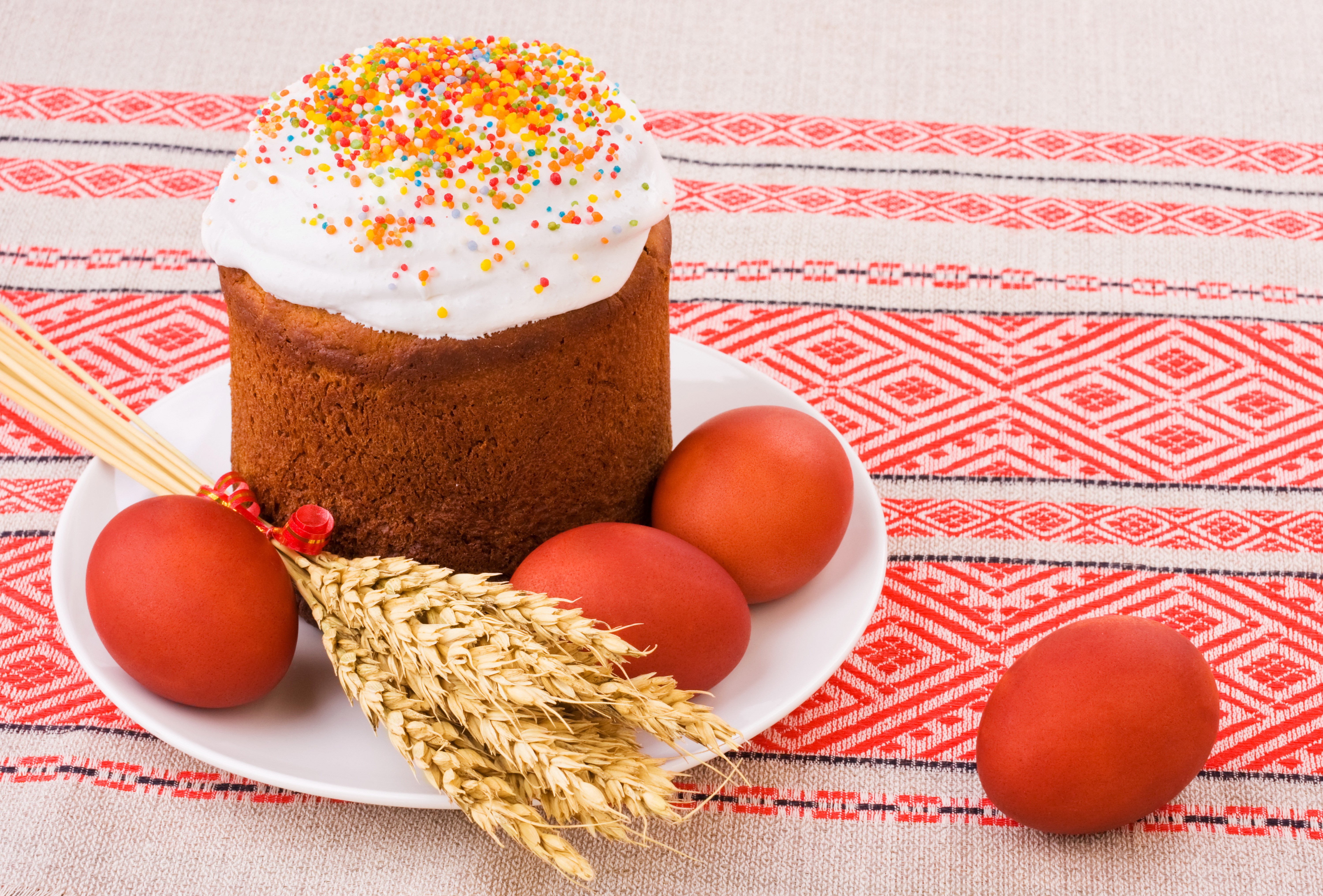 Easter Kulich with red eggs and wheat on a patterned tablecloth HD Wallpaper