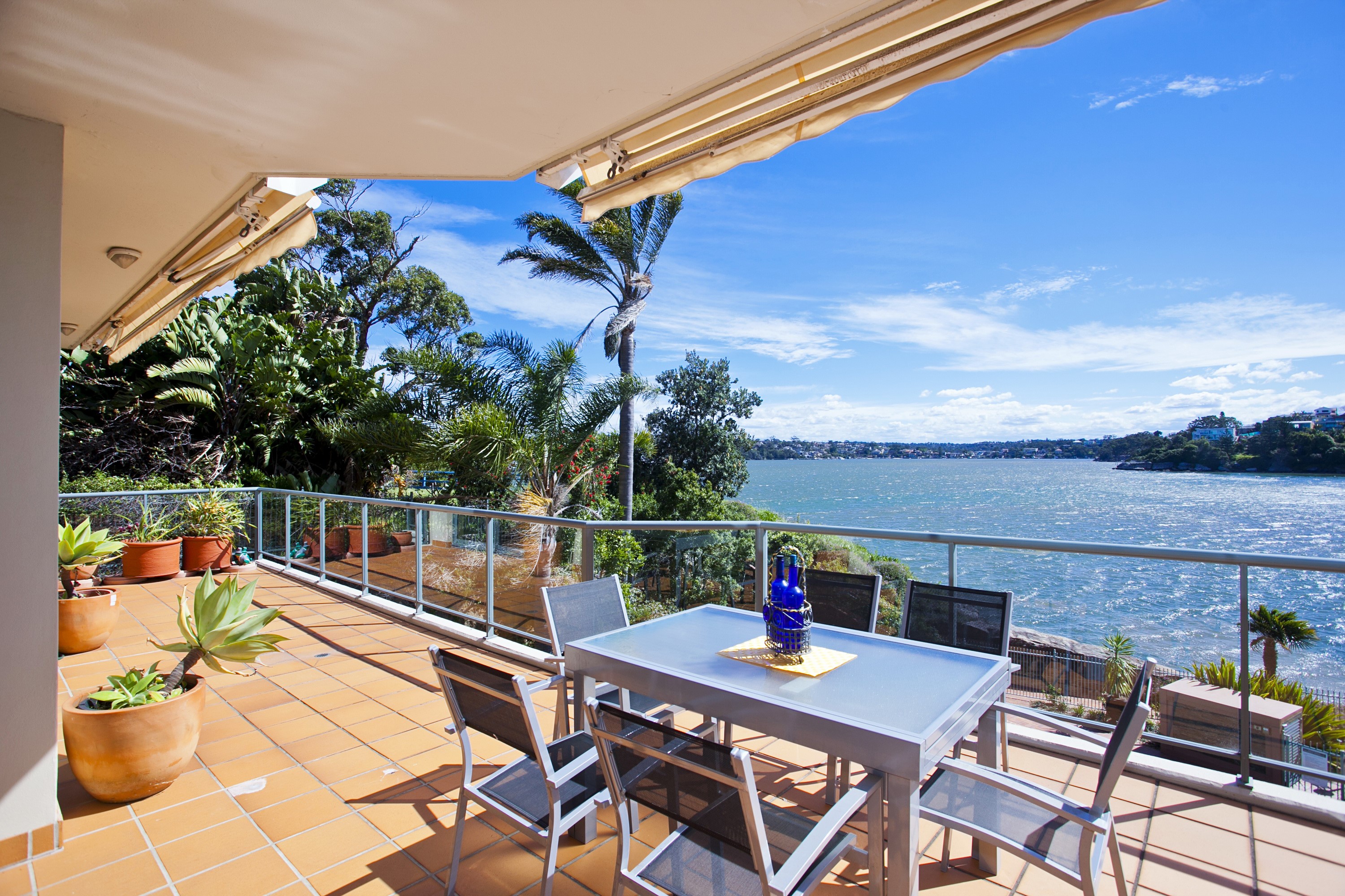 Balcony overlooking a wide river with lush greenery HD Wallpaper