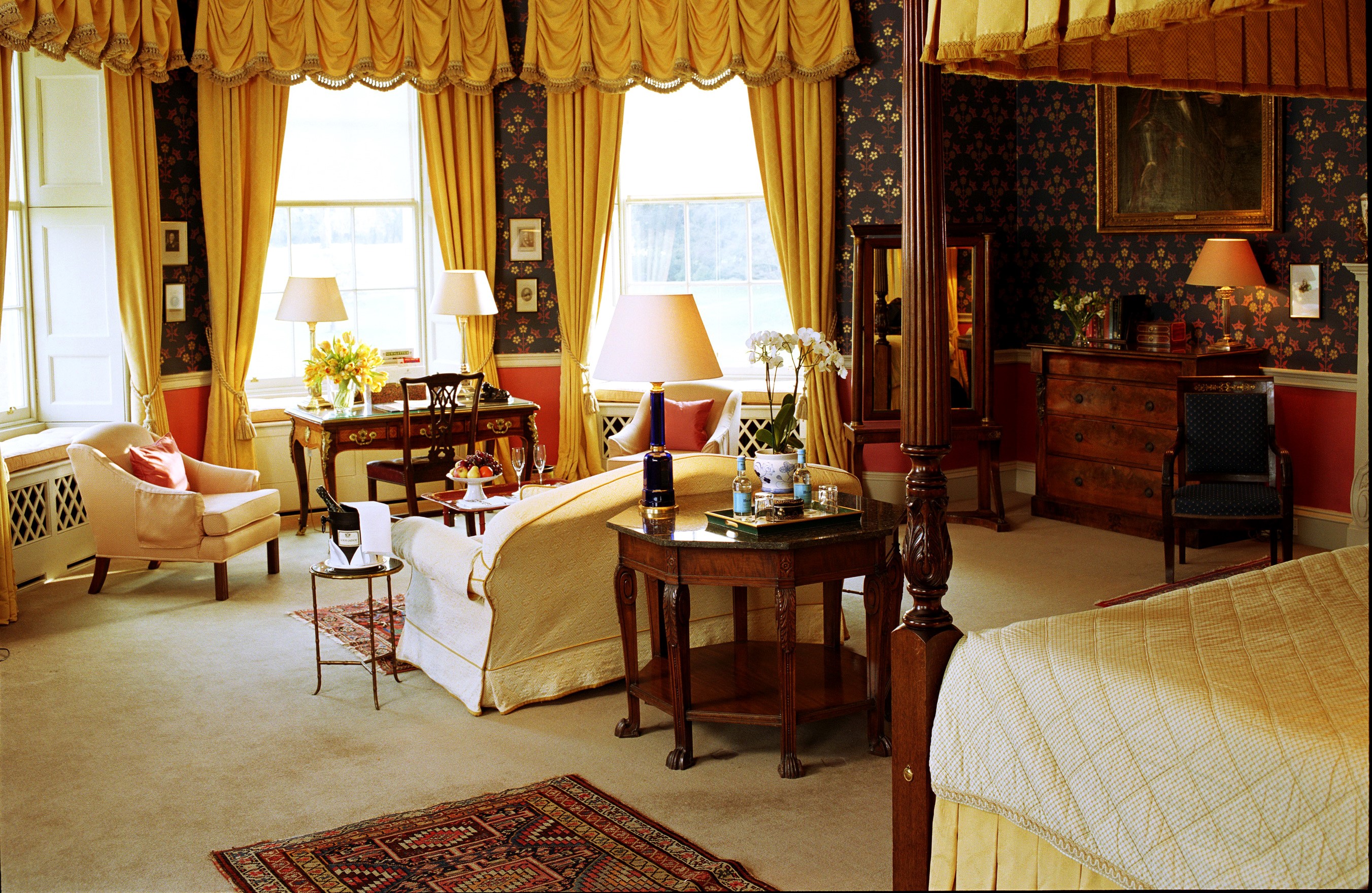Luxurious hotel room with four-poster bed and seating area HD Wallpaper