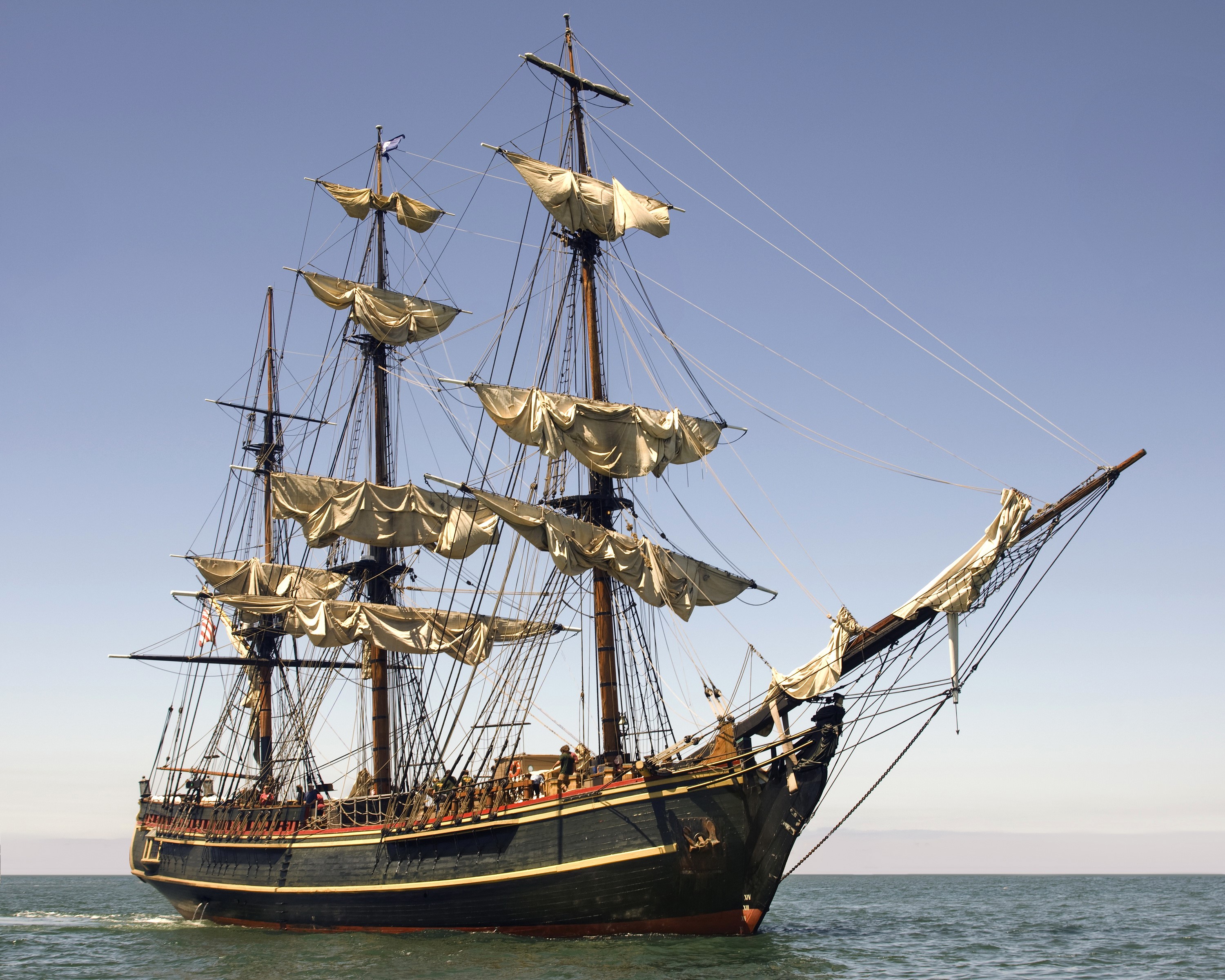 A tall ship with sails billowing in the ocean HD Wallpaper