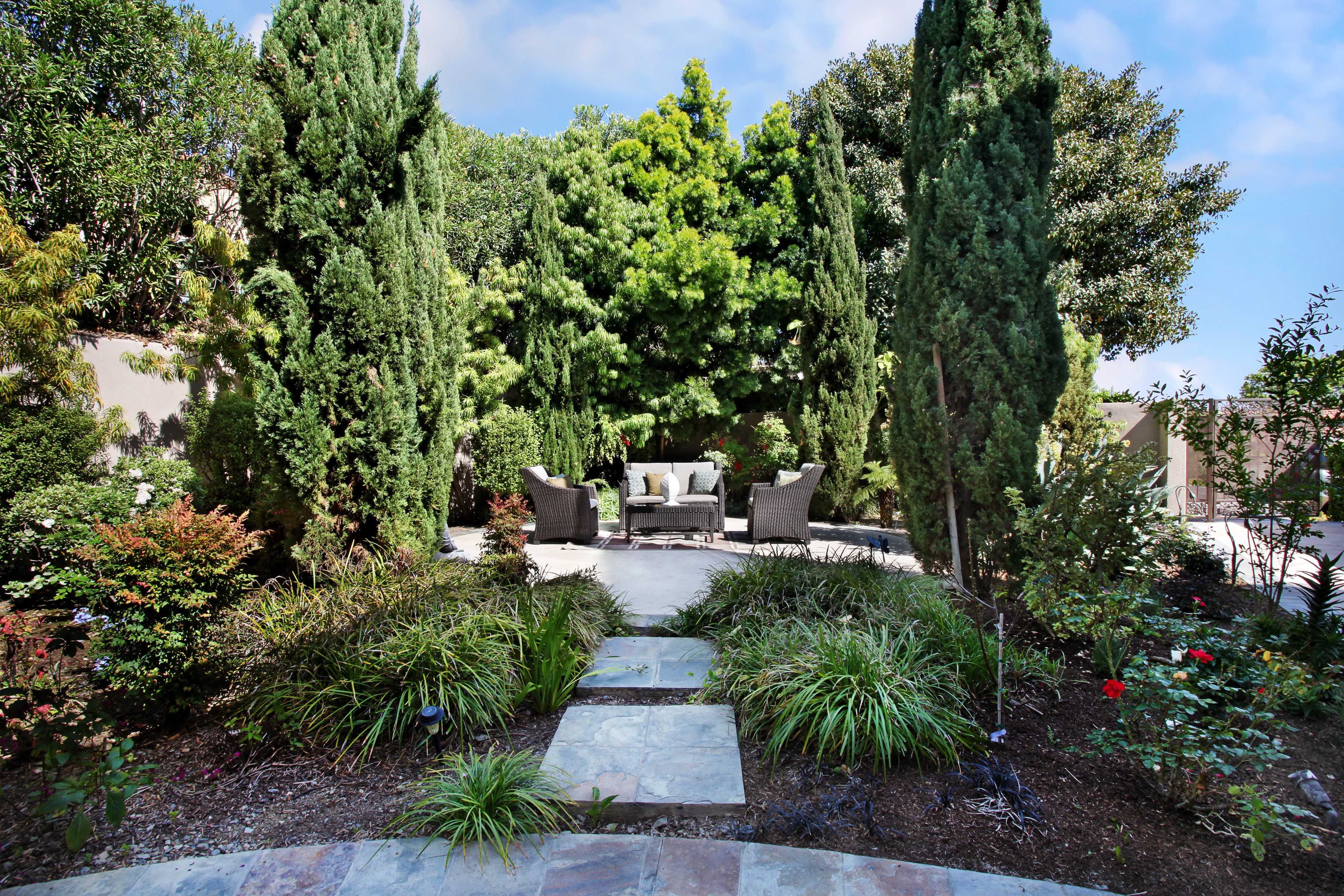 Outdoor seating area surrounded by trees and shrubs HD Wallpaper