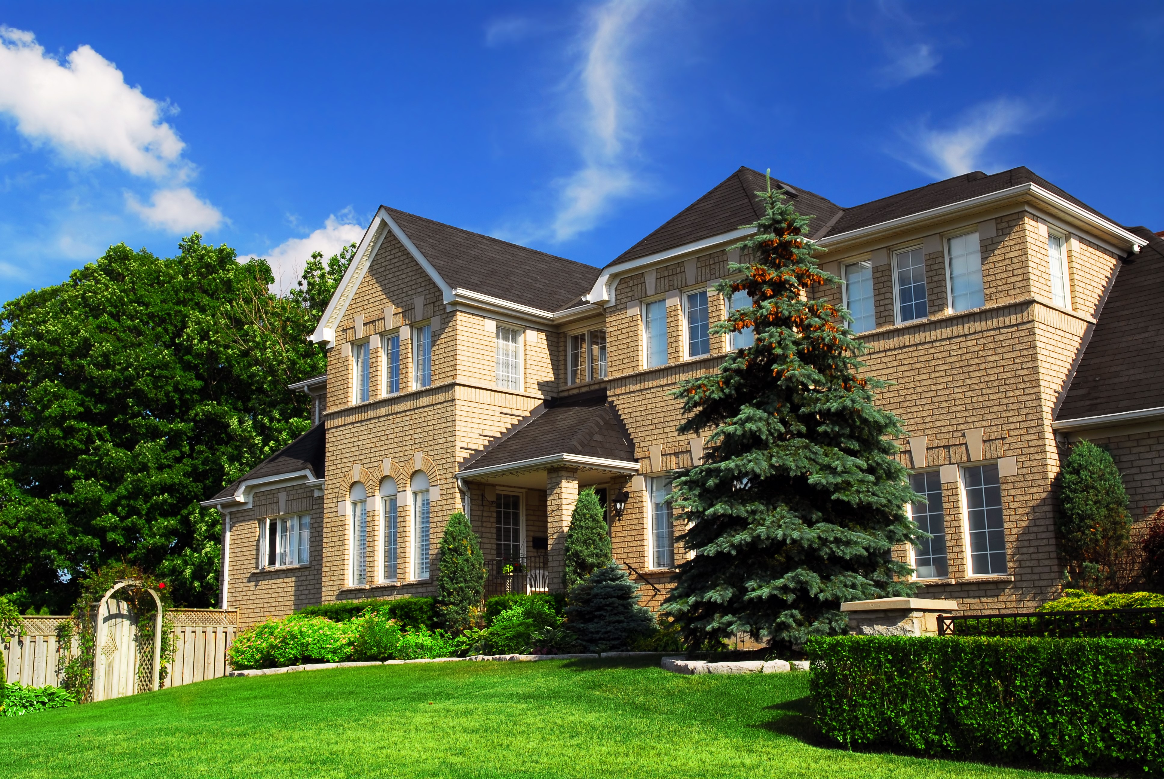 Large brick house with manicured lawn and trees HD Wallpaper