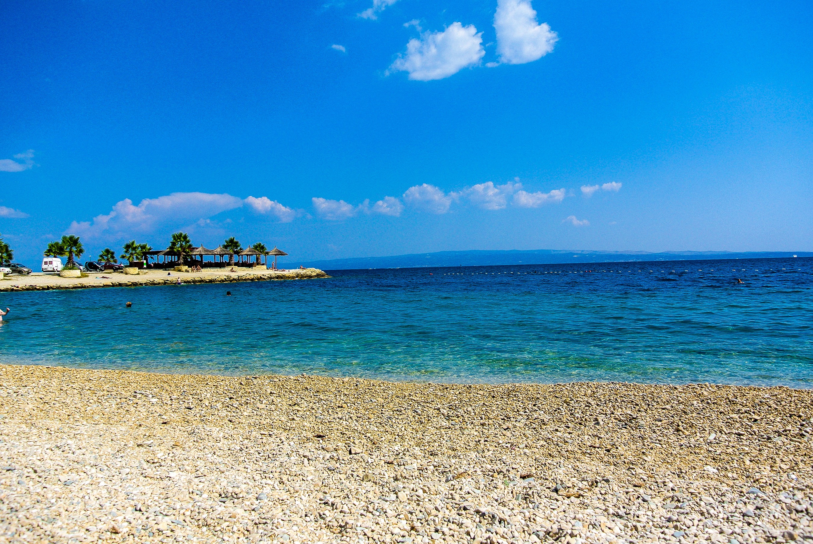 Beach with umbrellas and palm trees in Croatia HD Wallpaper