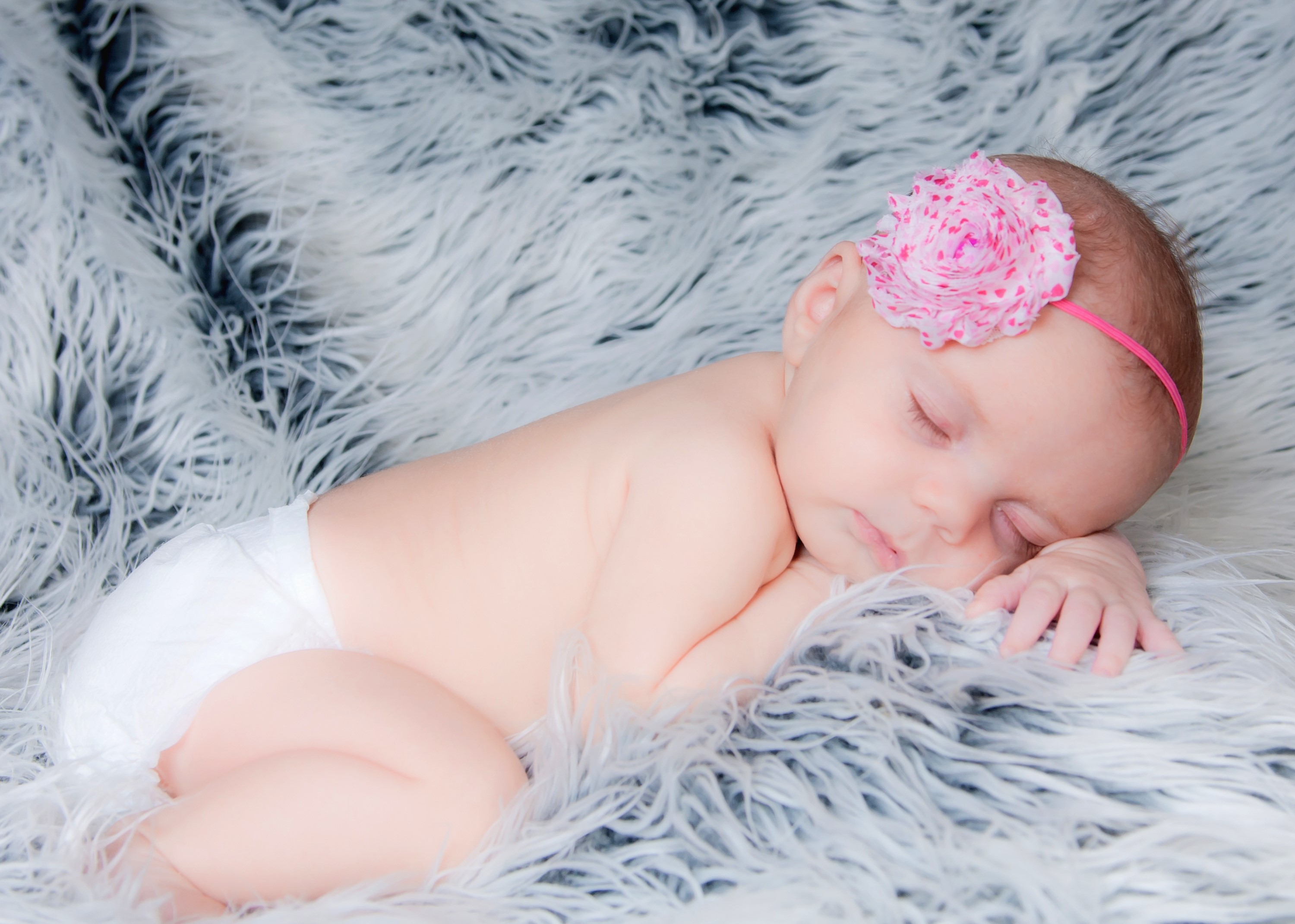 Newborn baby girl sleeping on a fluffy blanket HD Wallpaper