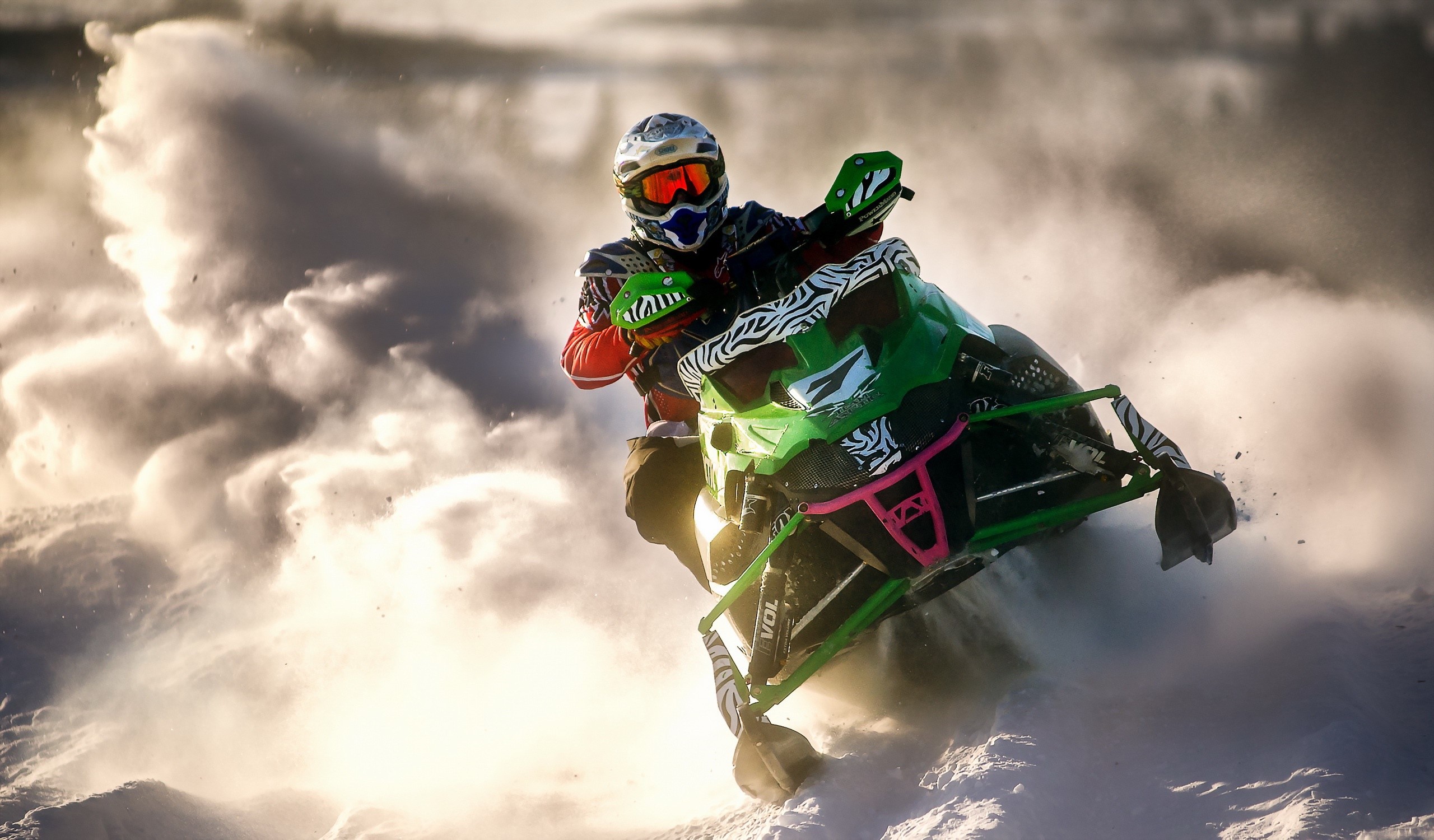 Snowmobiler in action on a snowy landscape HD Wallpaper