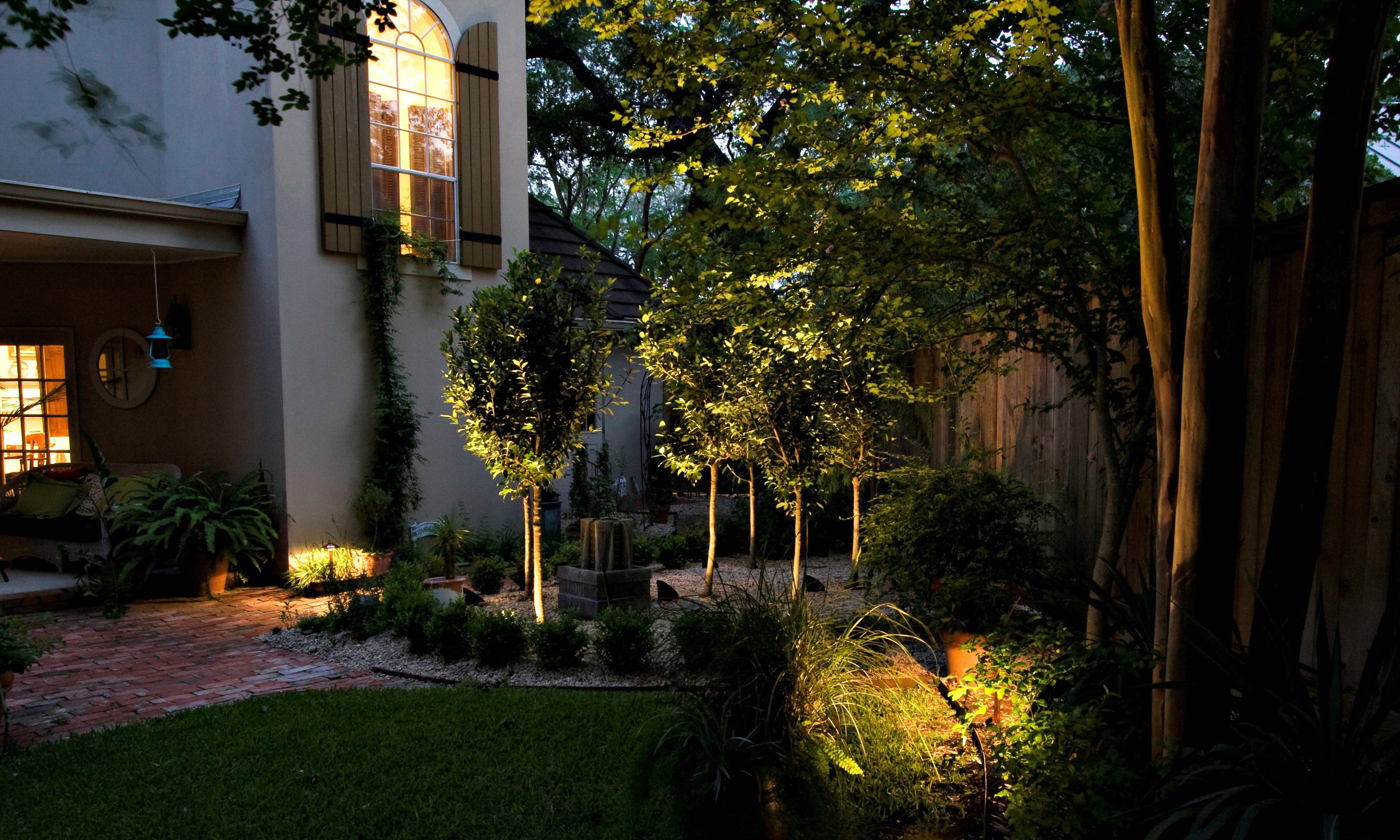 Garden with illuminated trees and house at dusk HD Wallpaper