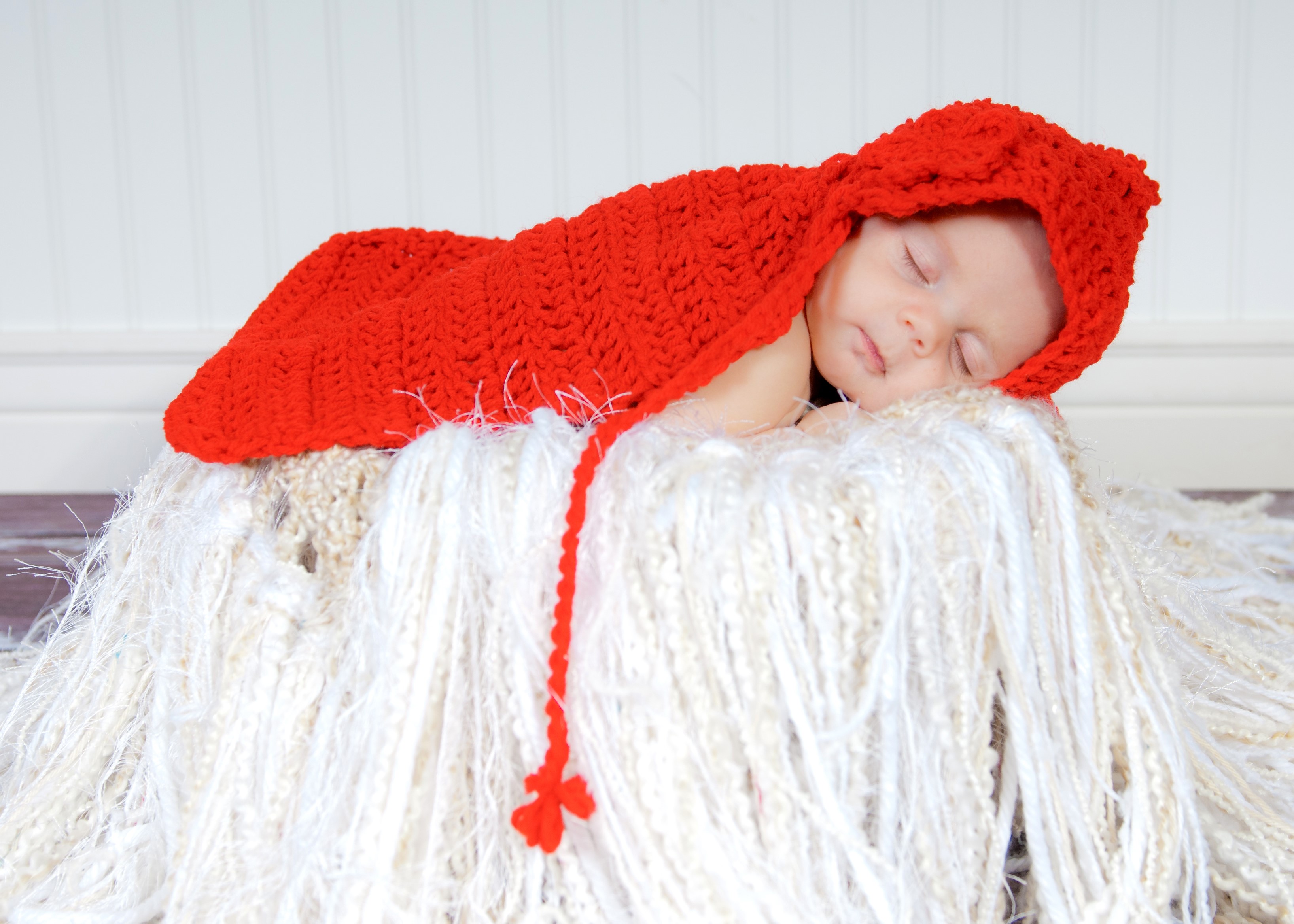 Baby sleeping in a red hooded blanket HD Wallpaper