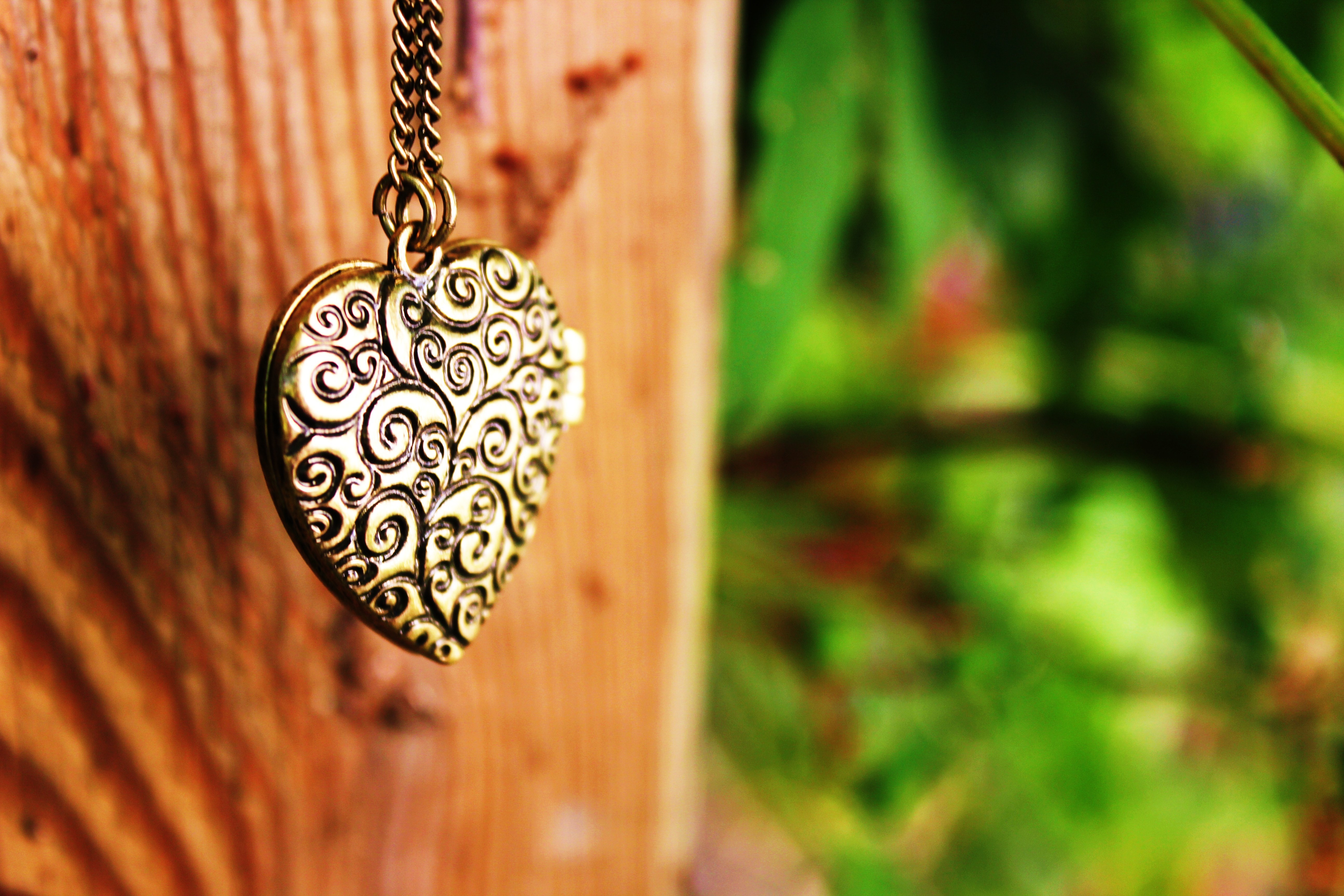 Heart locket necklace on wooden post HD Wallpaper