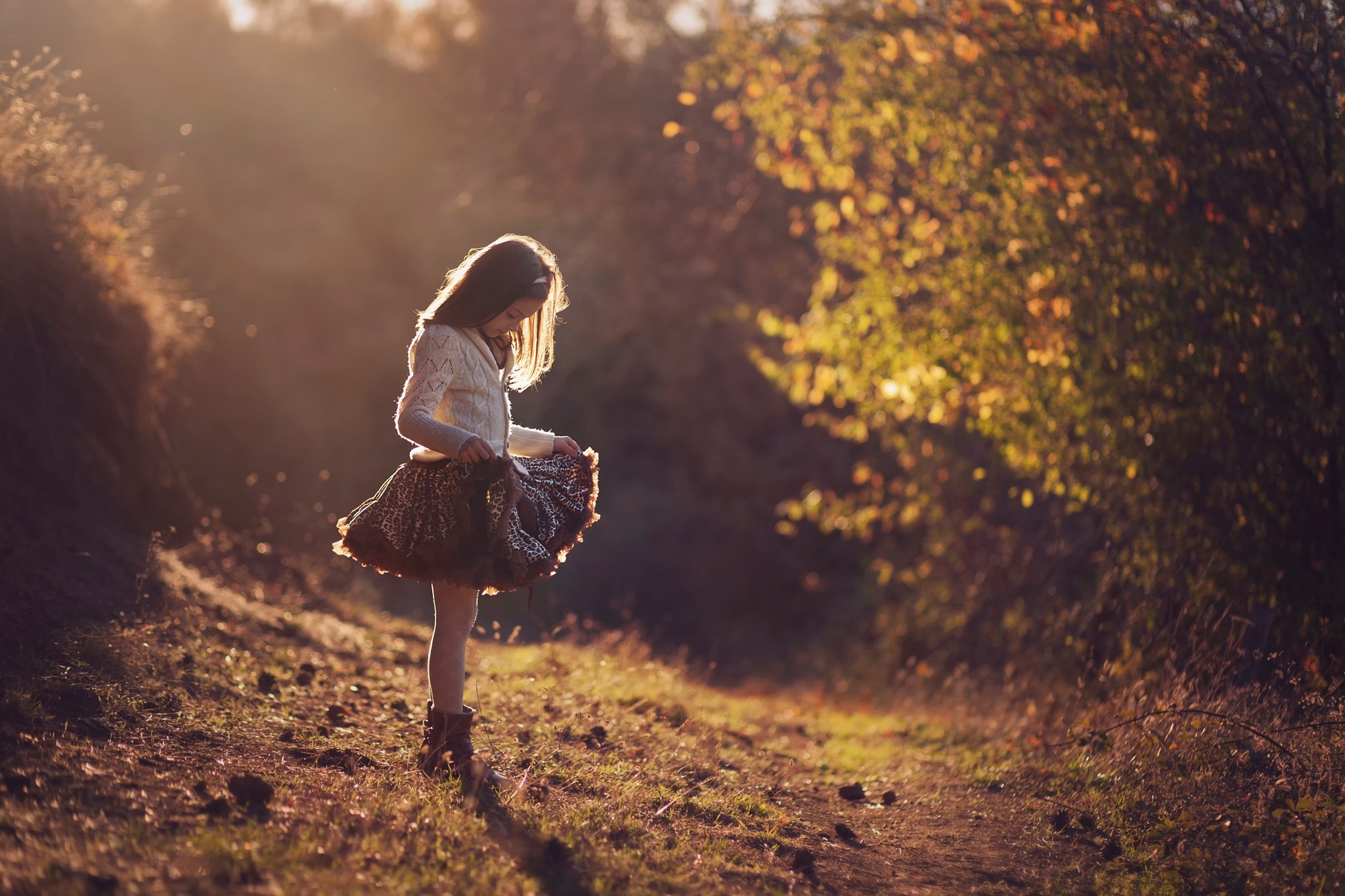 Young girl in a skirt in a sunlit forest HD Wallpaper