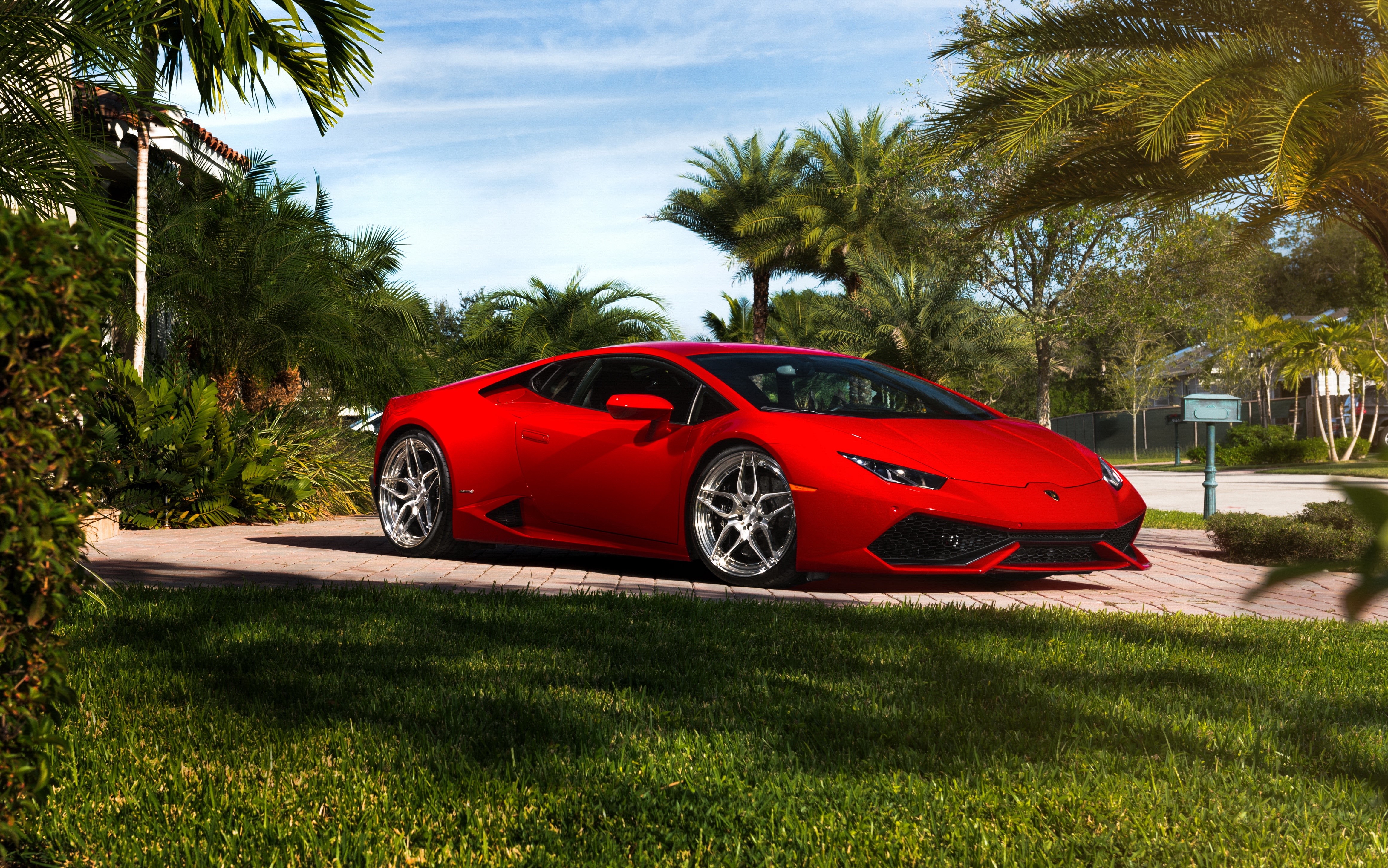 Red Lamborghini Huracan on a driveway with palm trees HD Wallpaper