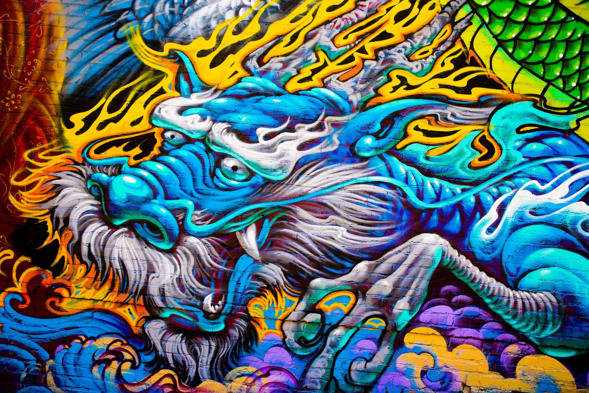 Graffiti of a blue and yellow dragon on a brick wall HD Wallpaper