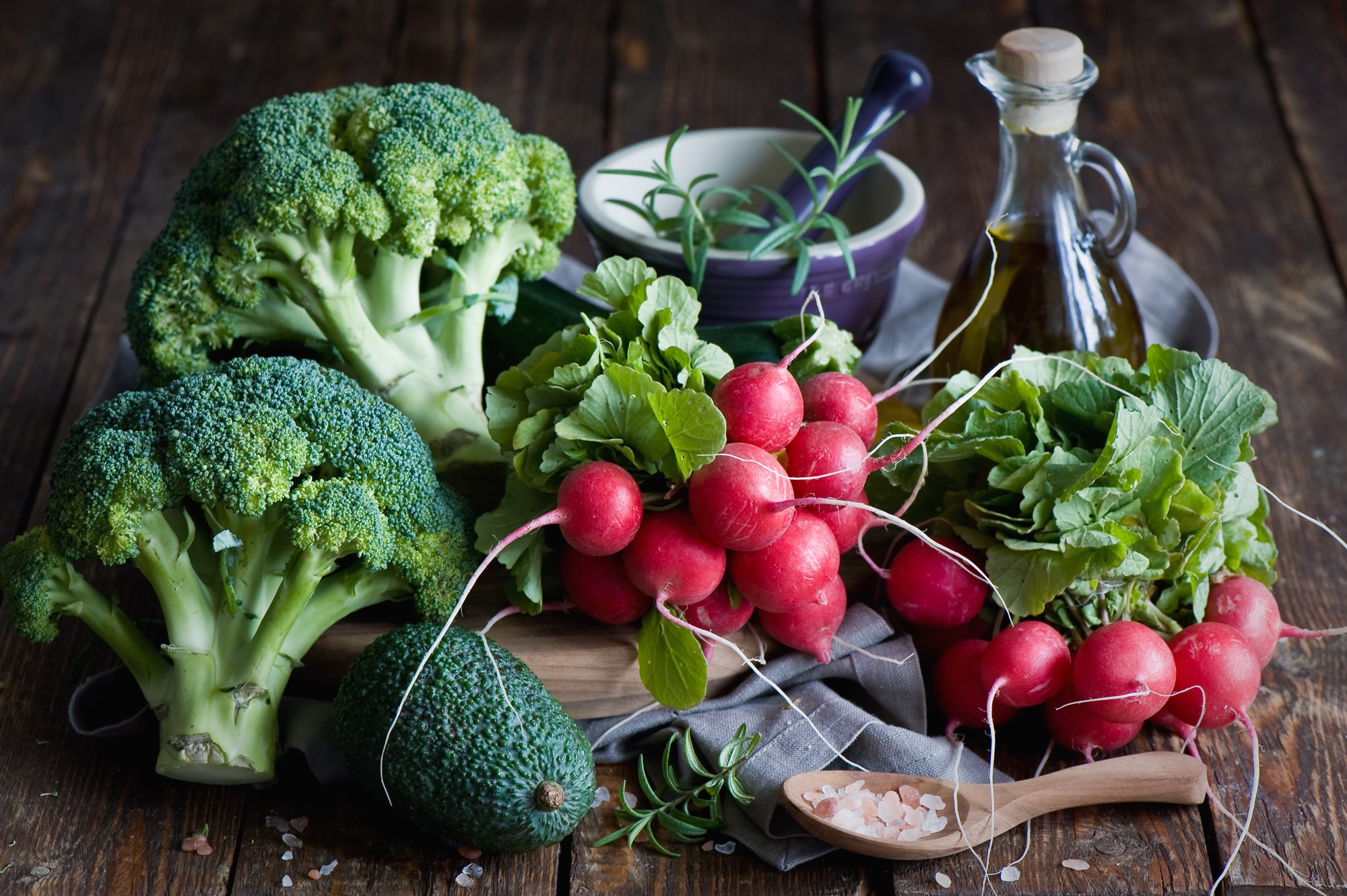 Broccoli, radishes, avocado, and olive oil on a wooden table HD Wallpaper