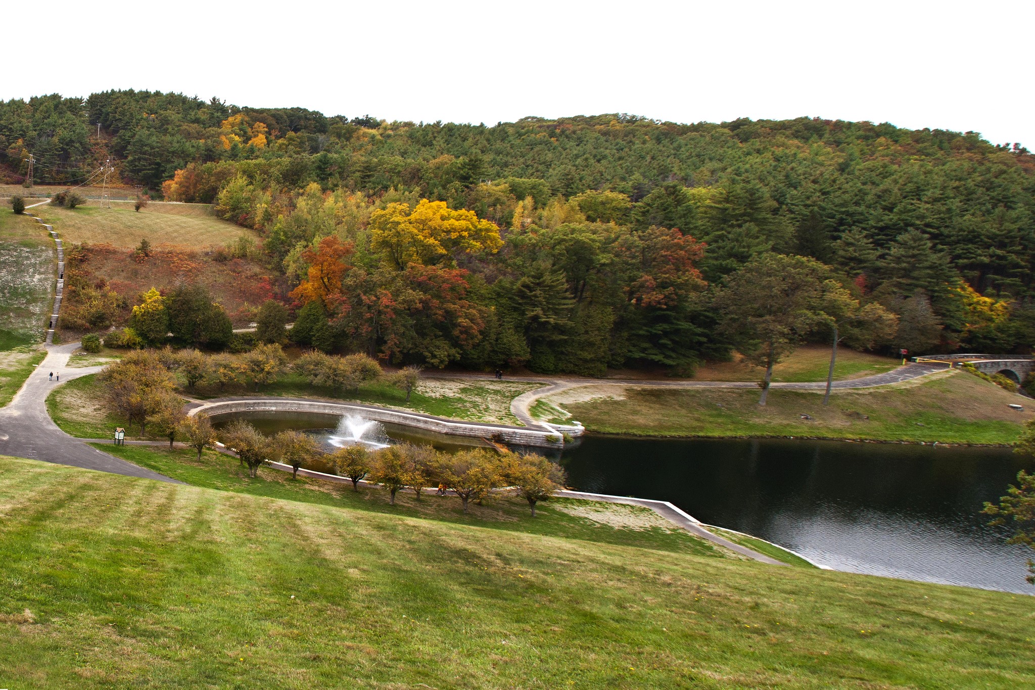 Autumn foliage around a pond with a fountain in Clinton, USA HD Wallpaper