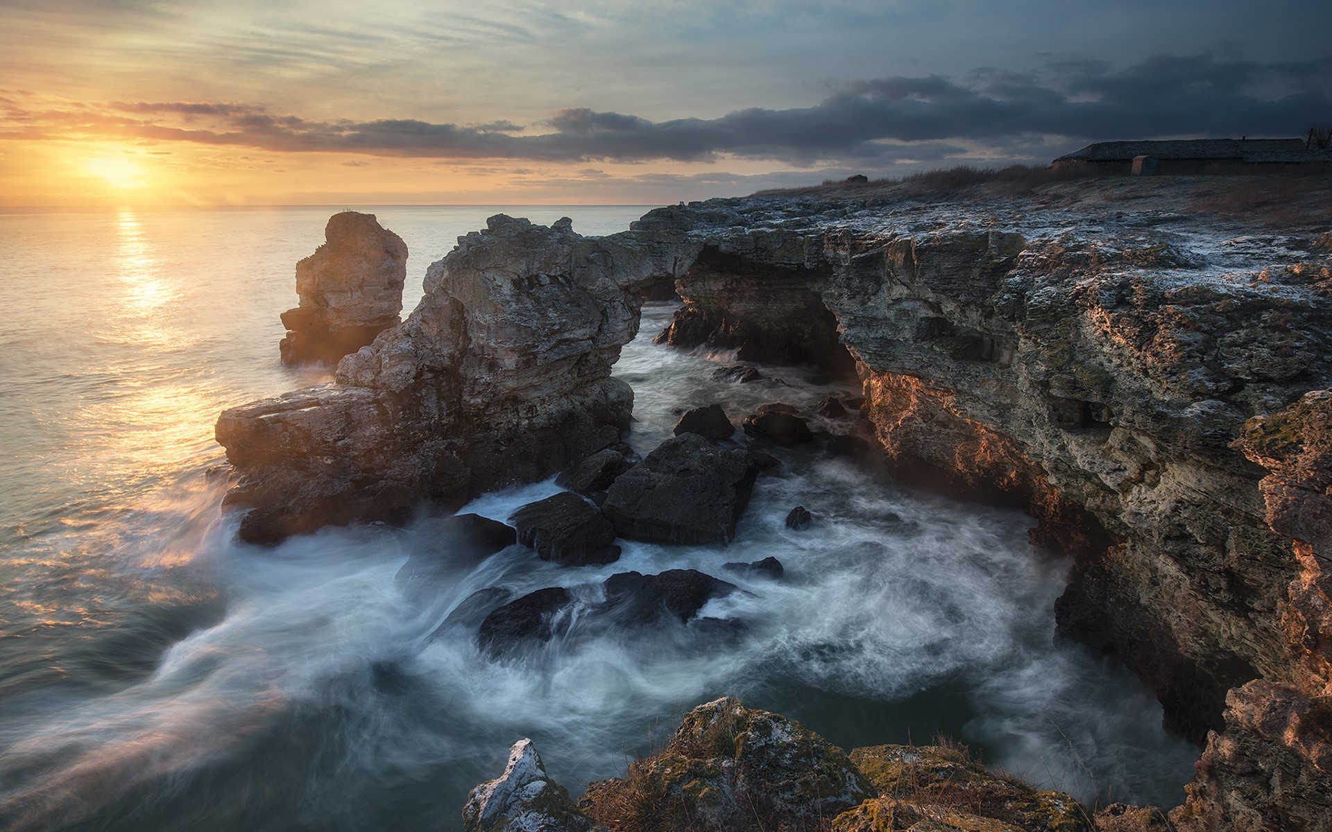 Sunrise over rocky coast with crashing waves HD Wallpaper