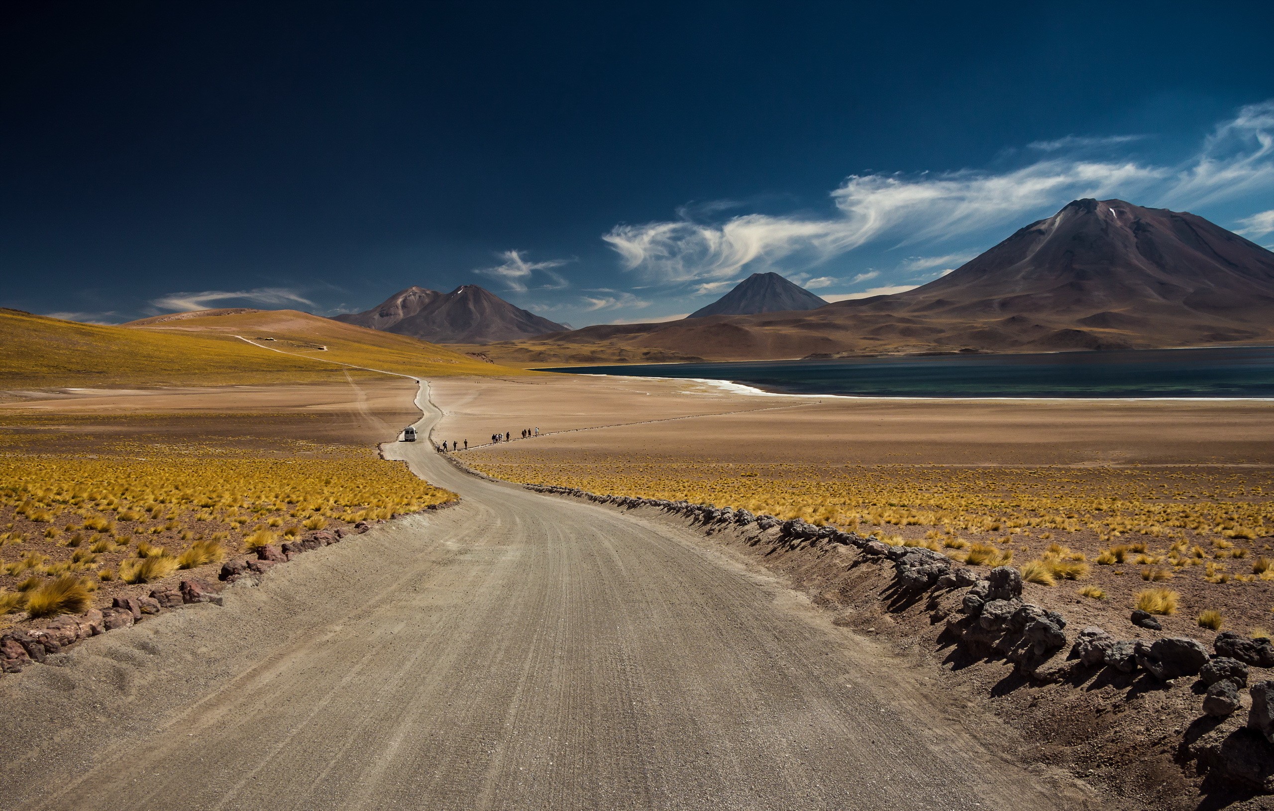 Dirt road leading to mountains and a lake HD Wallpaper
