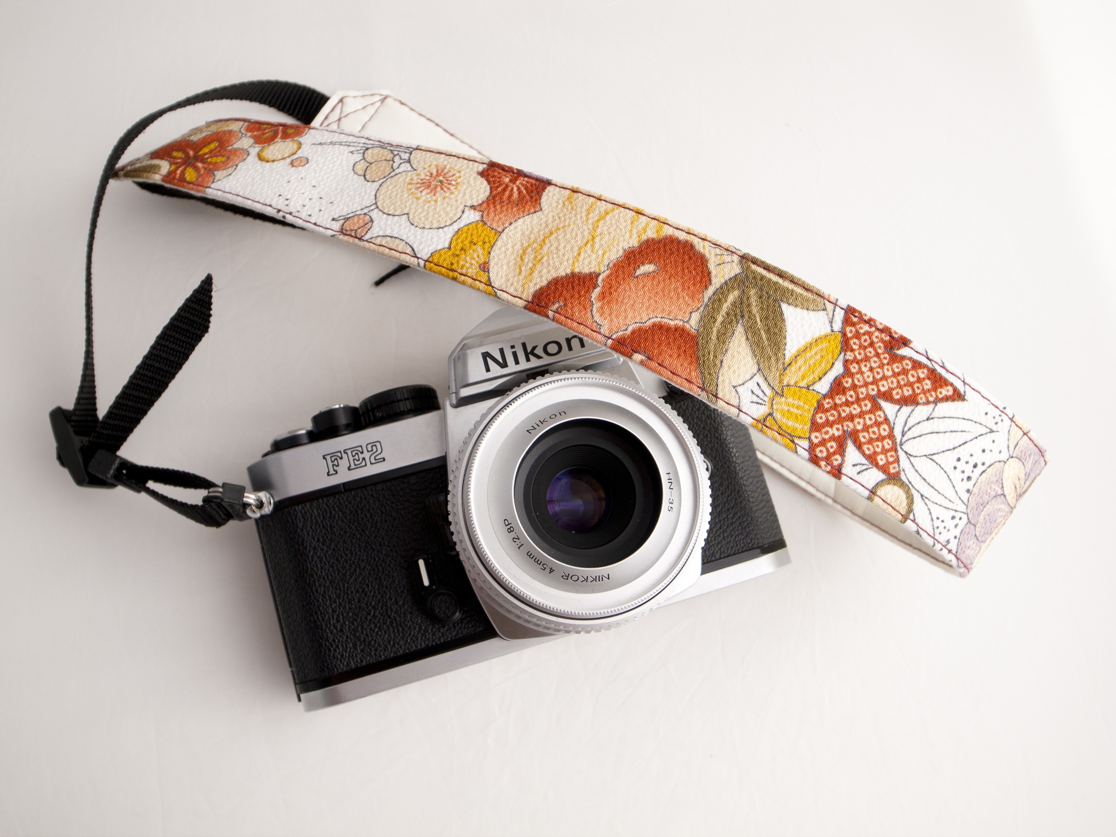 Nikon FE2 camera with floral strap HD Wallpaper